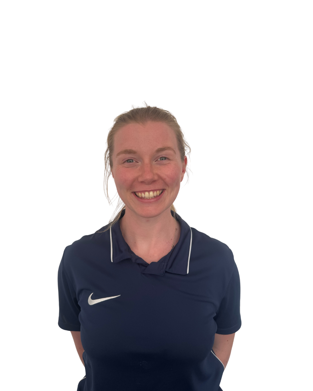 Smiling woman with red hair in a navy blue Nike sports shirt, standing against a white background.