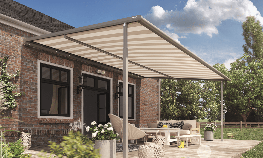 Outdoor patio with striped awning, beige furniture, potted plants, and trees in the background.