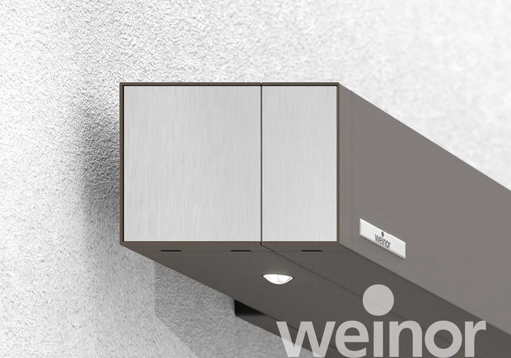 Close-up of a modern, wall-mounted, metallic emergency alarm unit labeled 'weior' with a small light and a round sensor on a white textured wall.