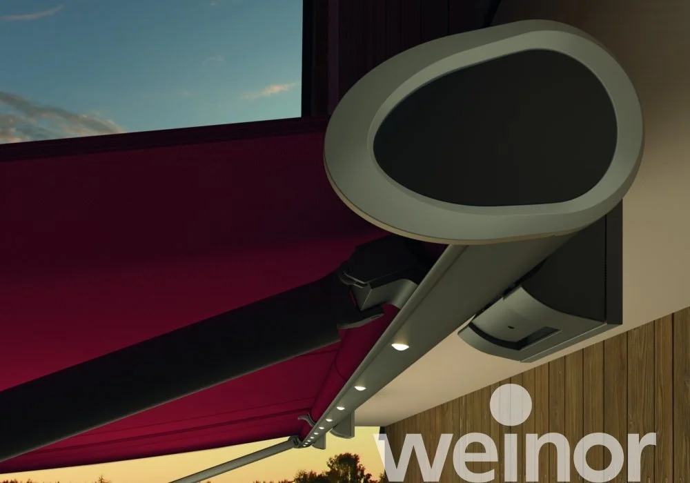 View of an indoor projection screen and a video projector mounted on the ceiling with the sky visible through a window.