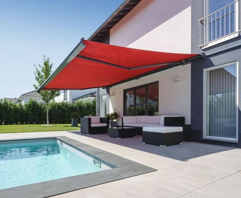 Modern backyard with a swimming pool, outdoor seating, and a large red retractable awning.