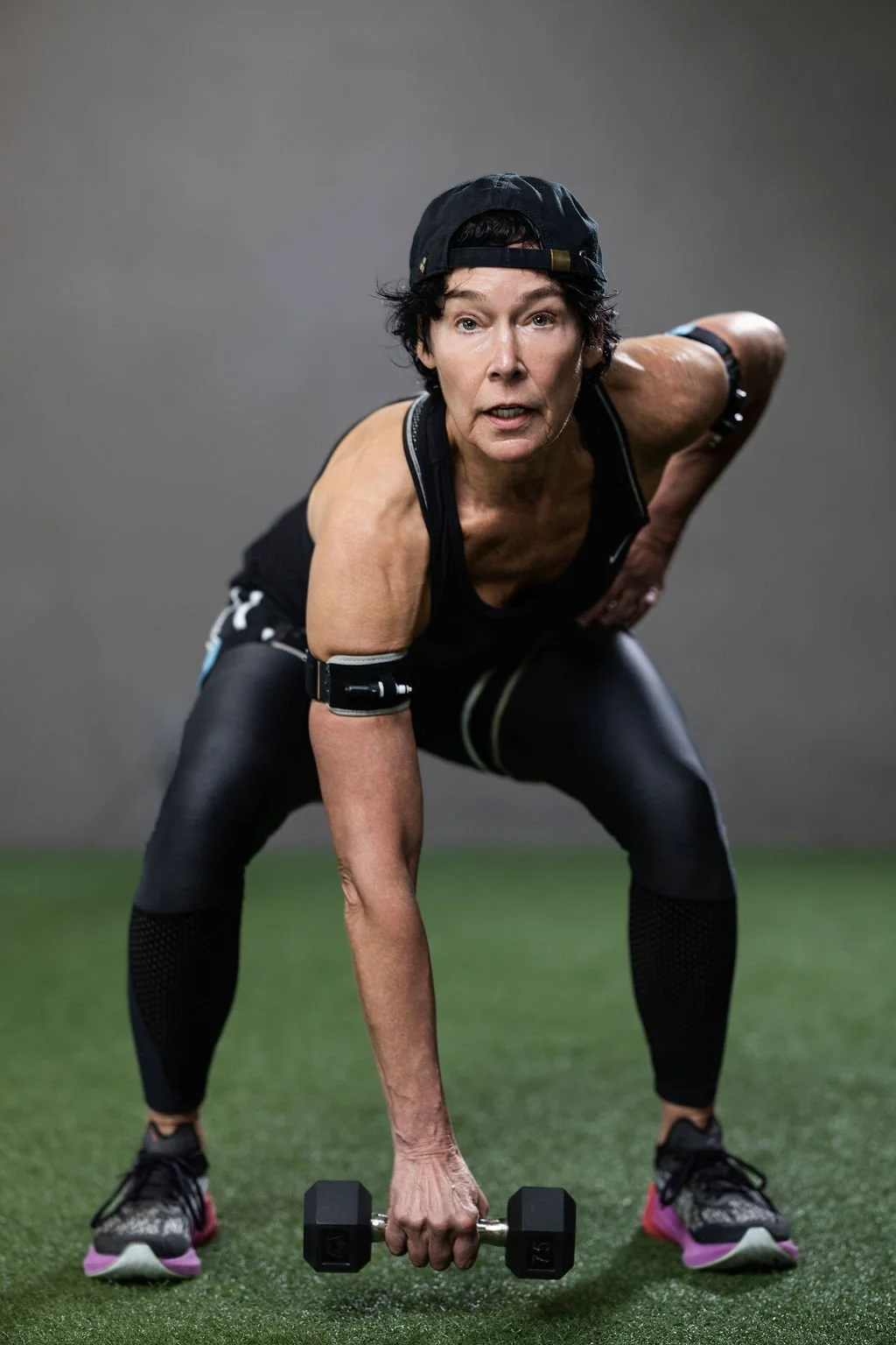 Woman performing a dumbbell strength exercise in a gym — Seli Strength BFR training program
