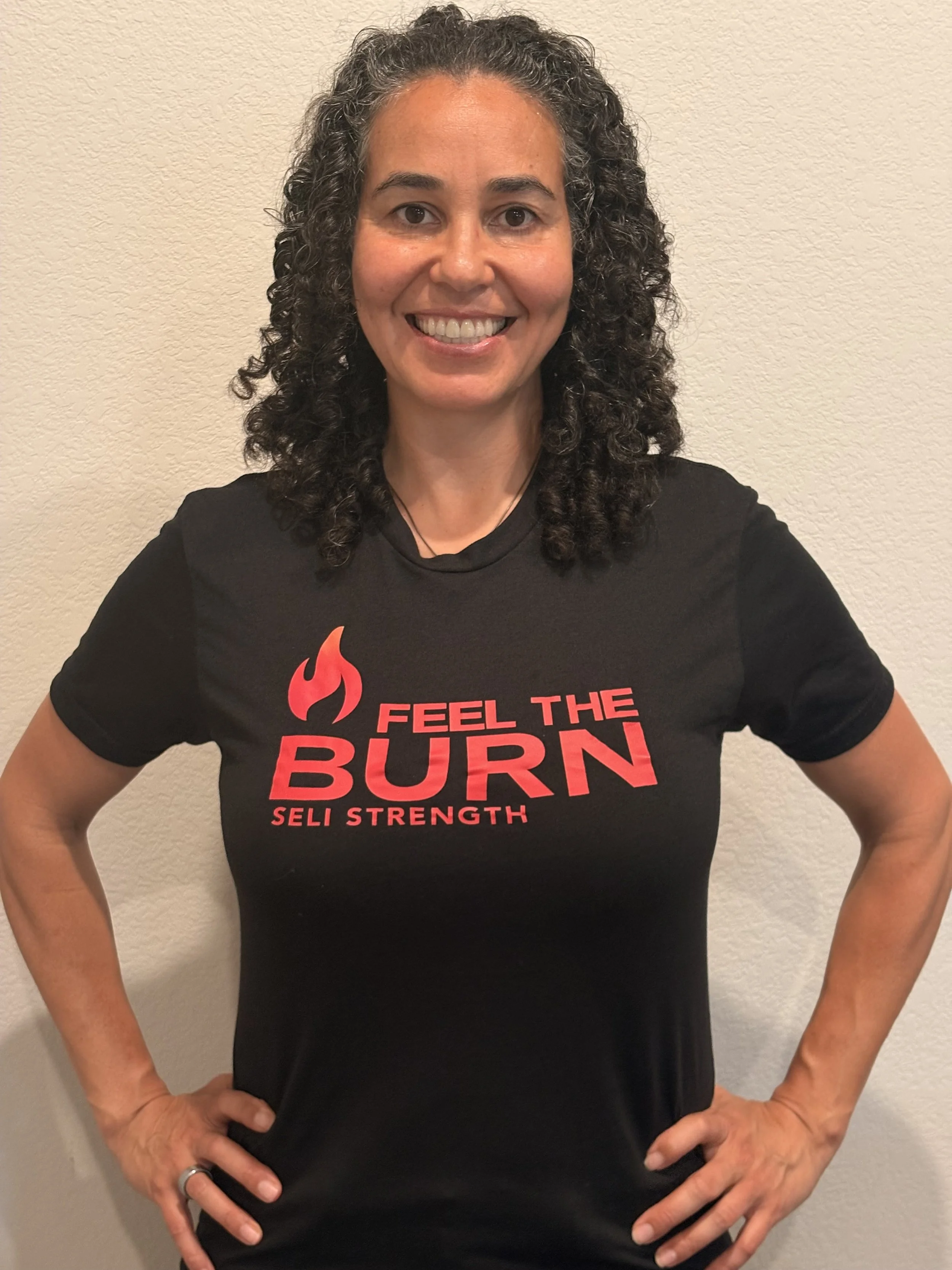 Coach Elaine Williams, Seli Strength trainer, smiling in a black tshirt