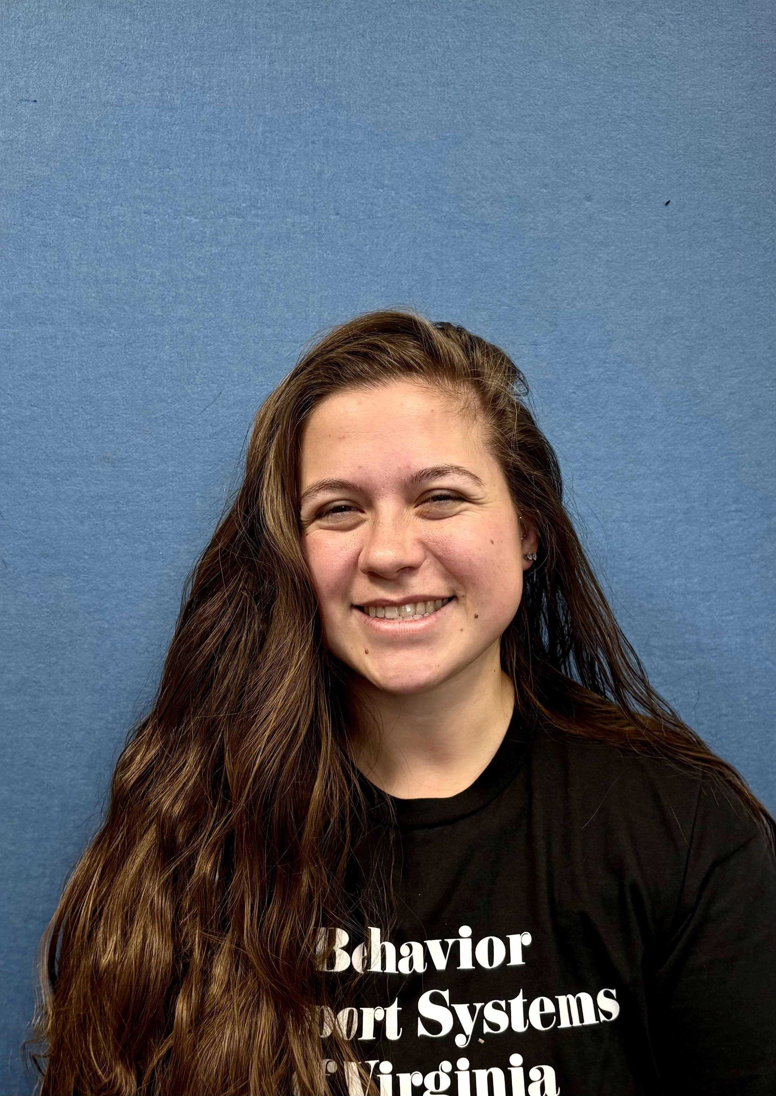 Person smiling against a blue background
