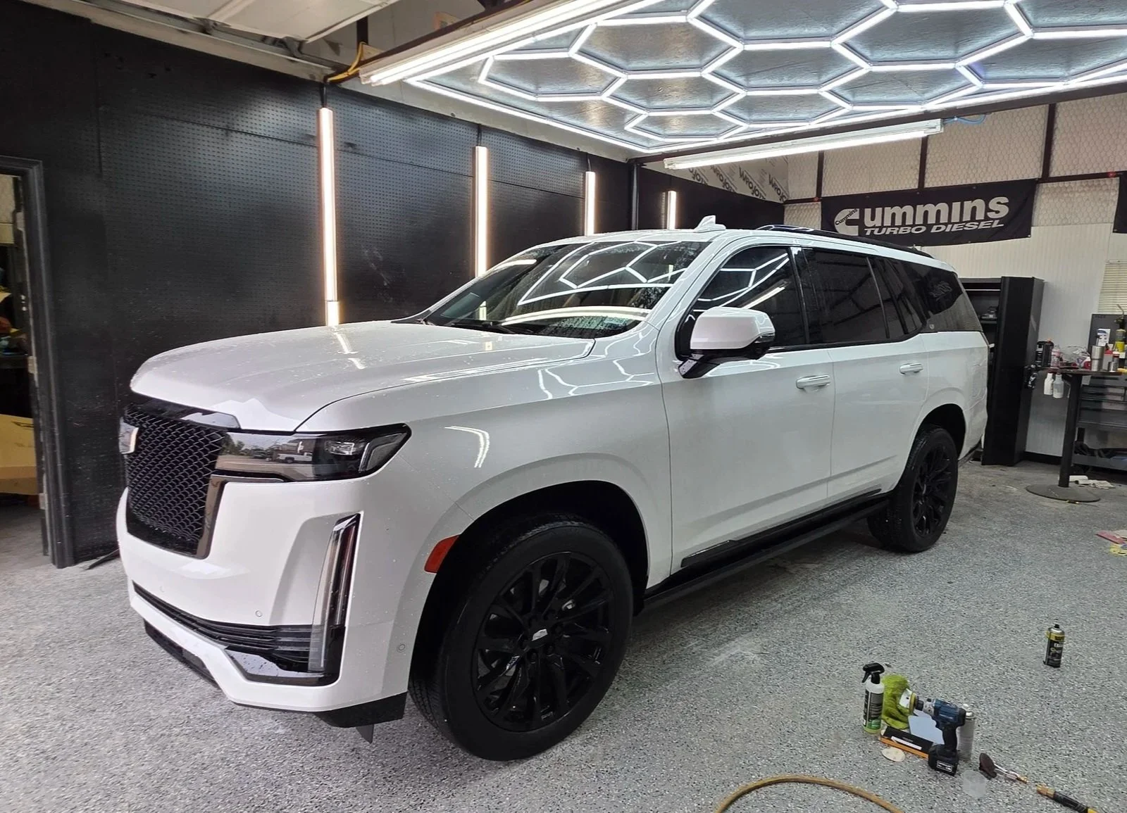 A white Cadillac inside detail studio for an exterior detail in Burleson, Tx