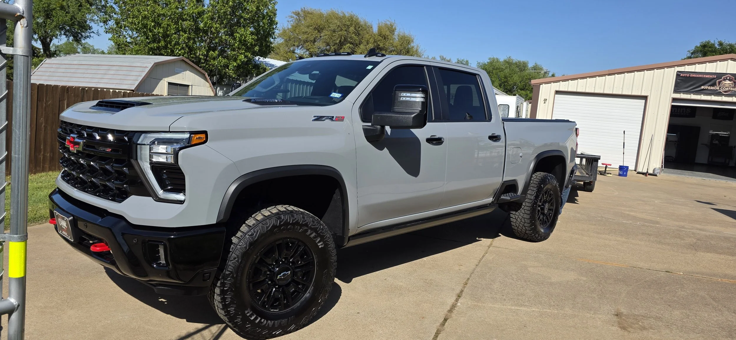 A gray Chevrolet Silverado pickup truck with black wheels and off-road tires maintenance detail at Superior Coatings Texas