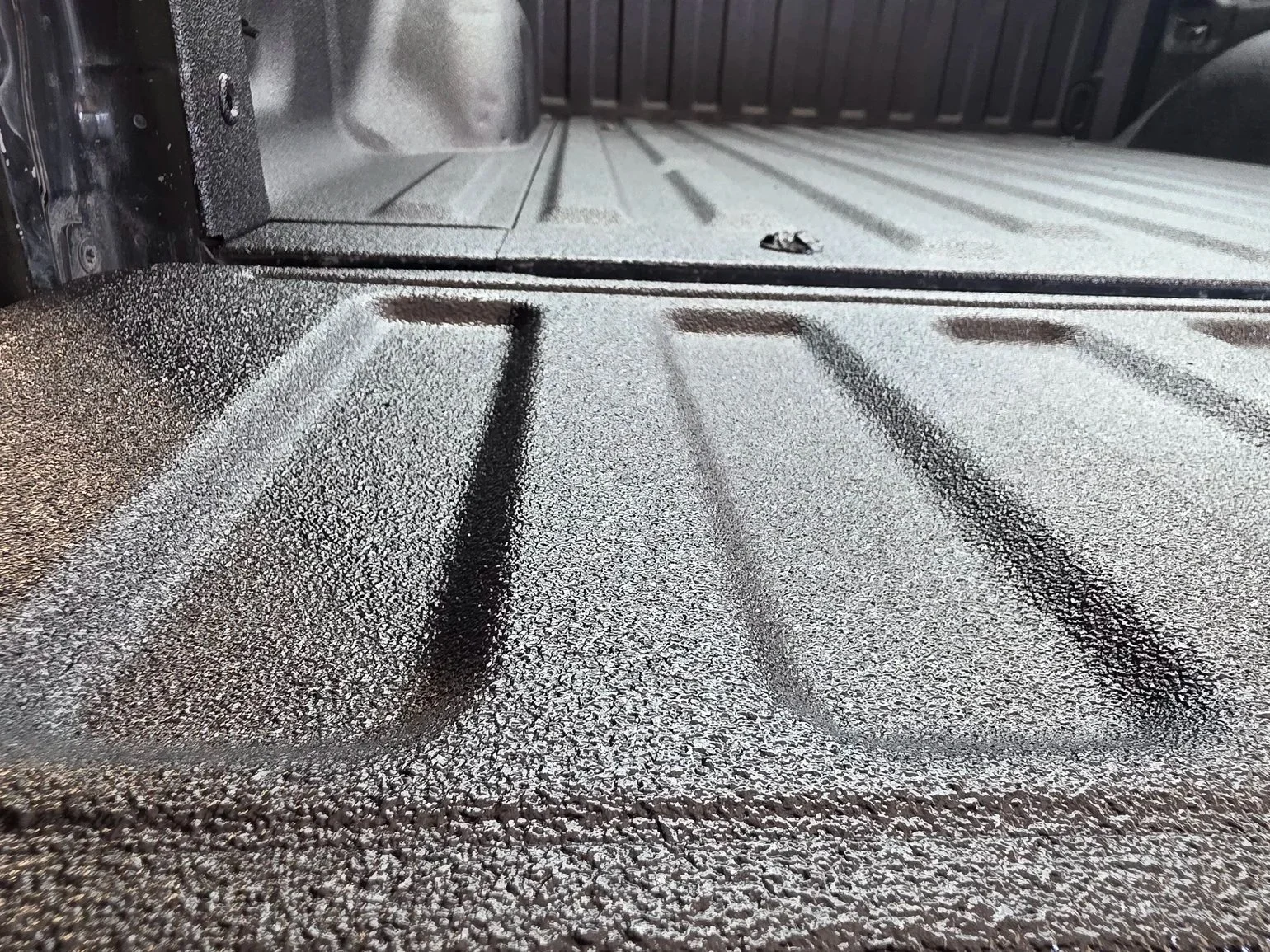 Close-up of a vehicle truck bed with a textured, spray-on liner coating in Burleson, TX 76028