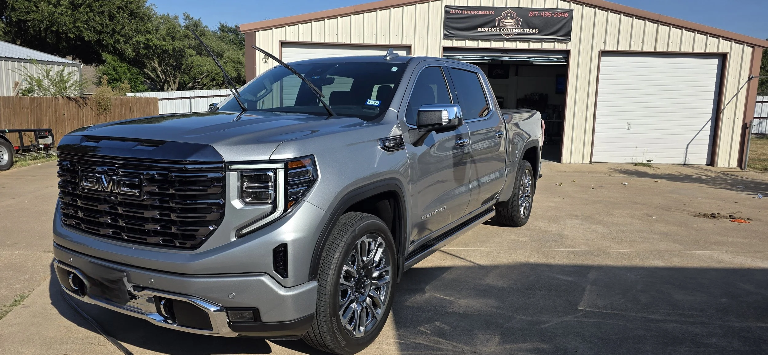 A silver GMC Denali Ultimate truck parked outside Superior Coatings Texas. coated with 5 year graphene matrix southern DFW metroplex Texas
