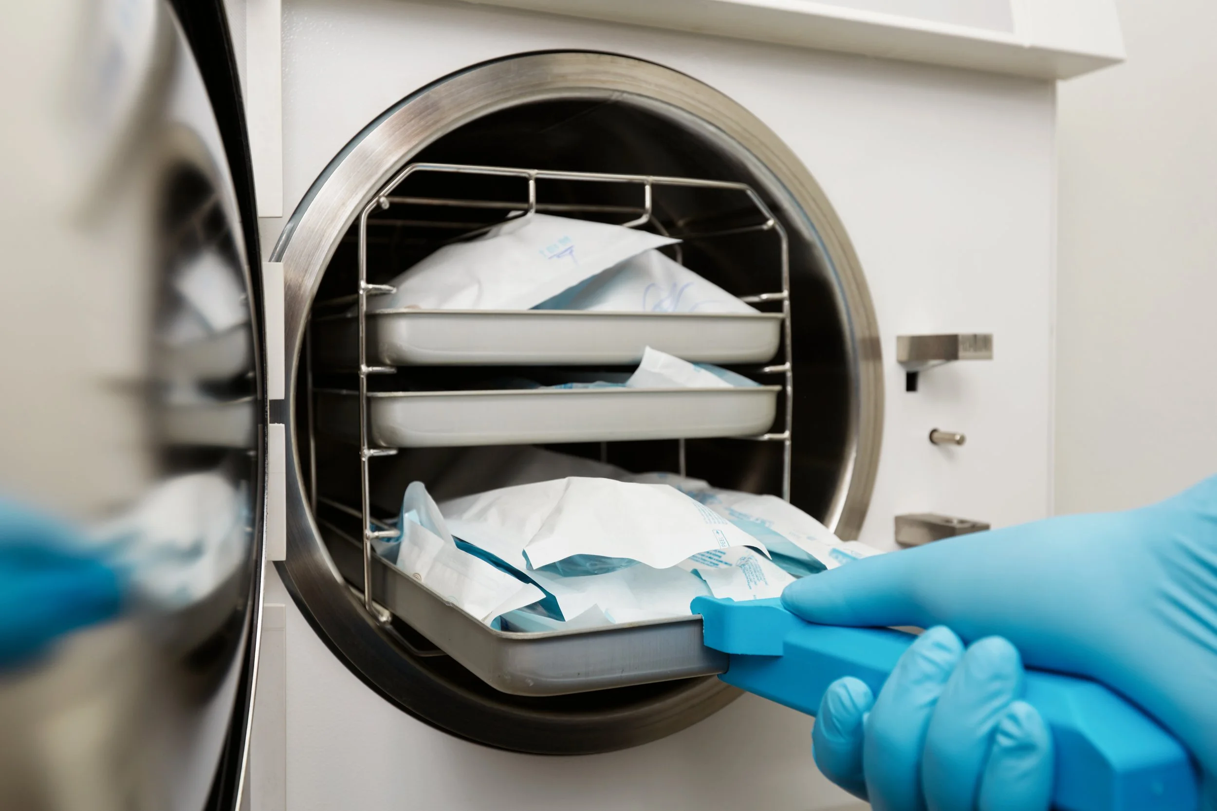 young-male-dentist-places-medical-autoclave-sterilising-surgical-other-instruments.jpg
