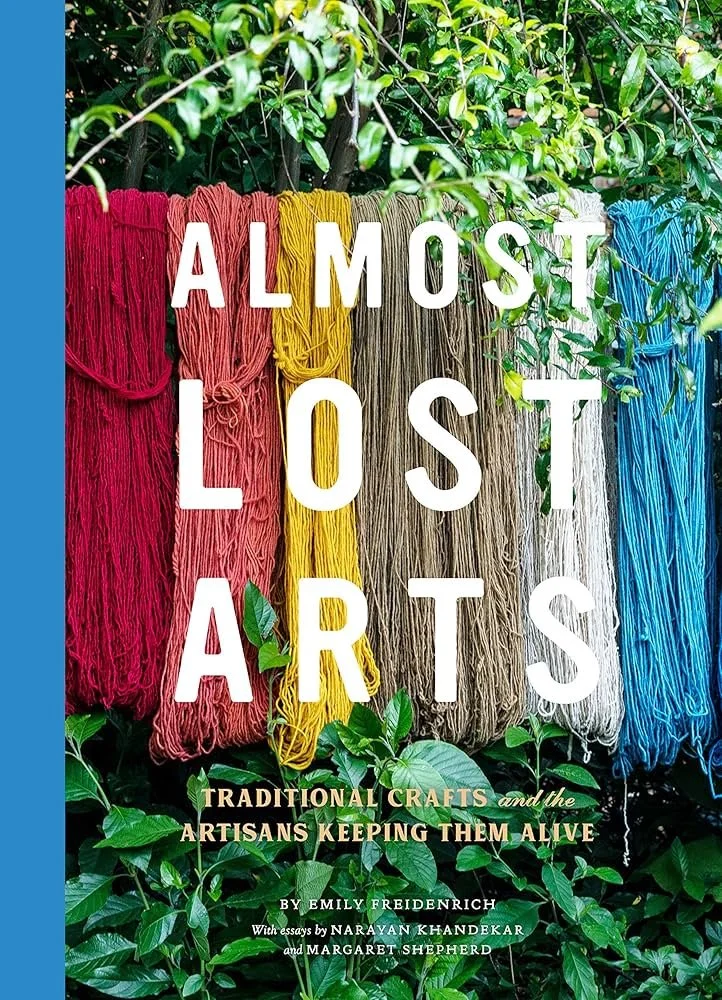 Book cover titled 'Almost Lost Arts' showing colored yarns hanging outdoors among green foliage, with subtitle about traditional crafts and artisans.