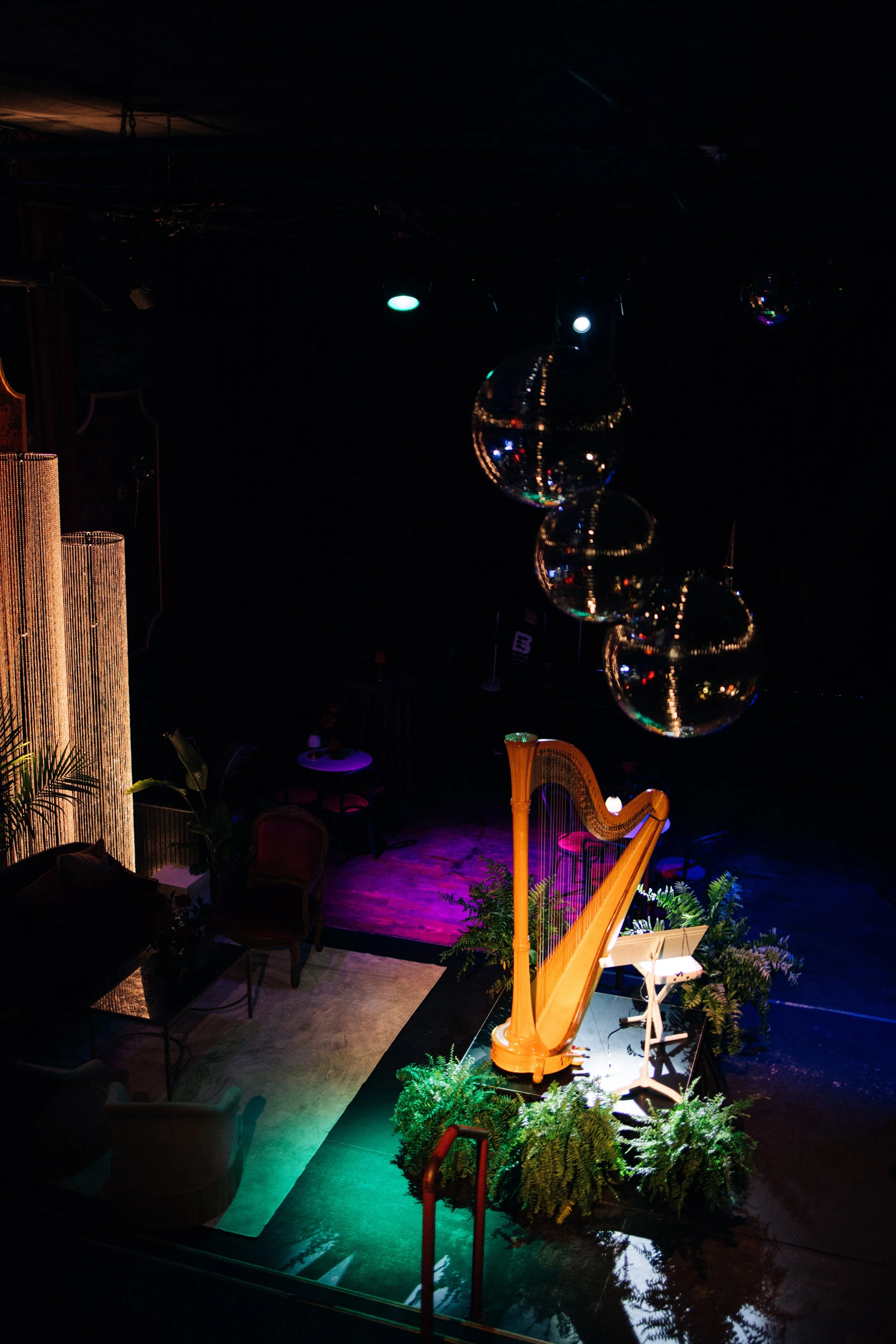 Event lounge featuring tropical greenery and designer furniture pairings.