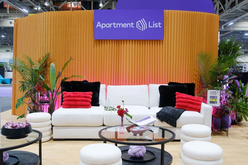 Convention booth styling with lush tropical plants and layered greenery.
