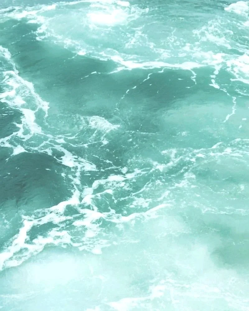 Eaux turquoise avec des vagues et de la mousse blanche à la surface de l'océan.