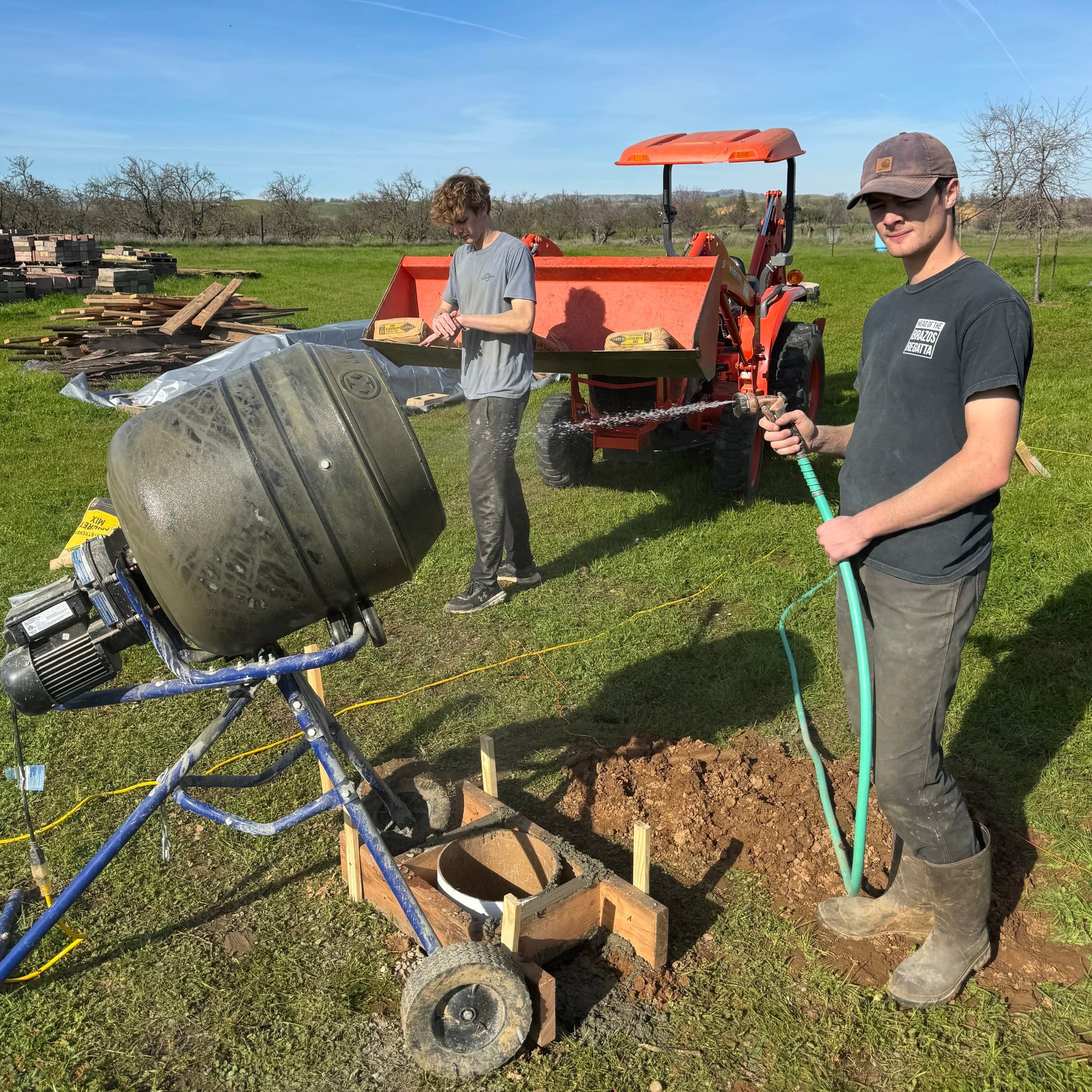 Boys, tractor and concrete pouring