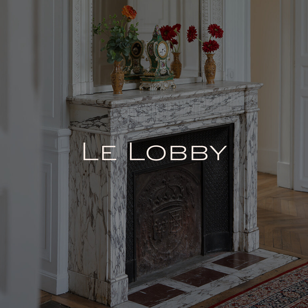 Une réception dans un hall avec une grande bouquet de fleurs blanches, un comptoir en marbre et une lampe suspendue