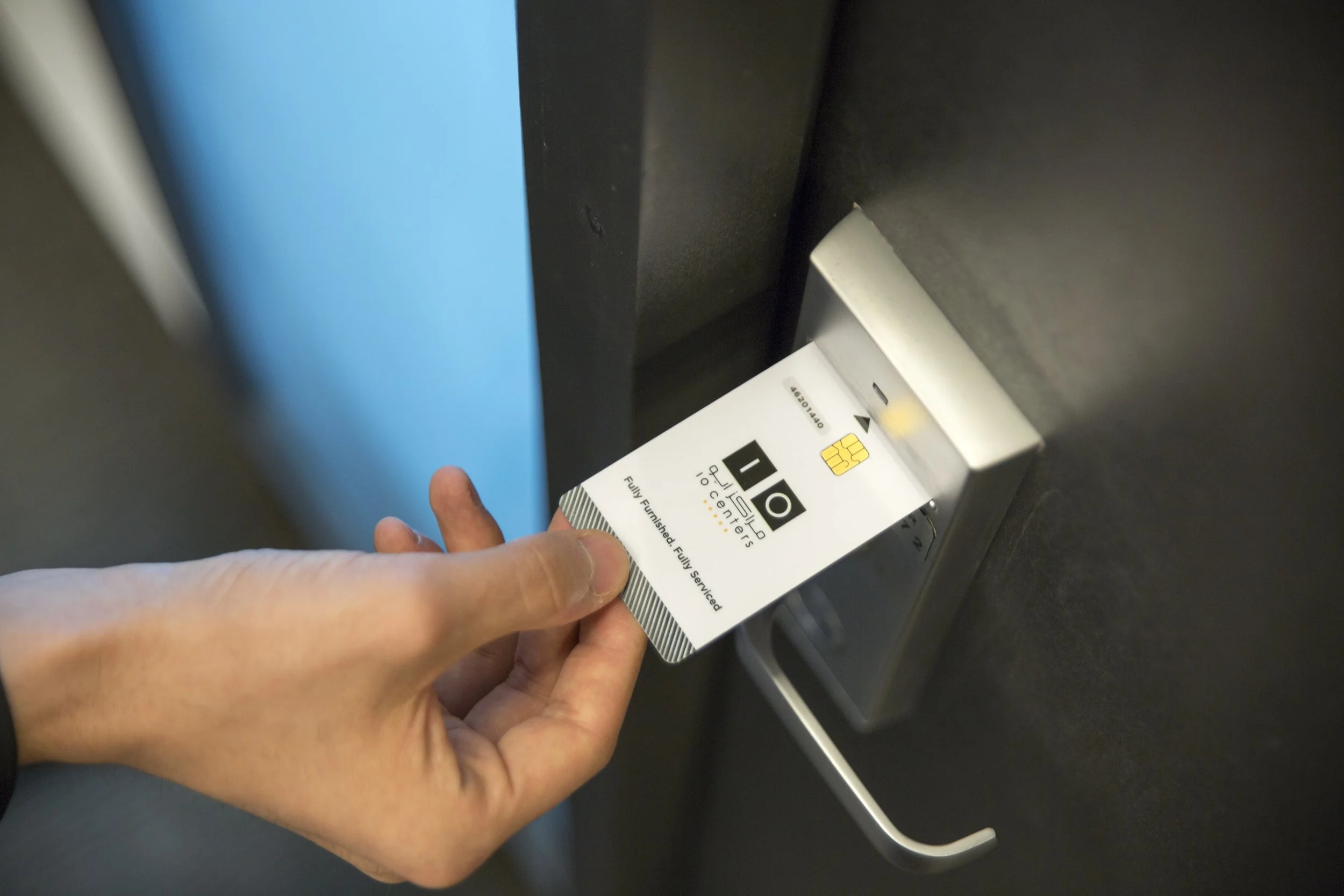 person scanning a door handle with a passkey
