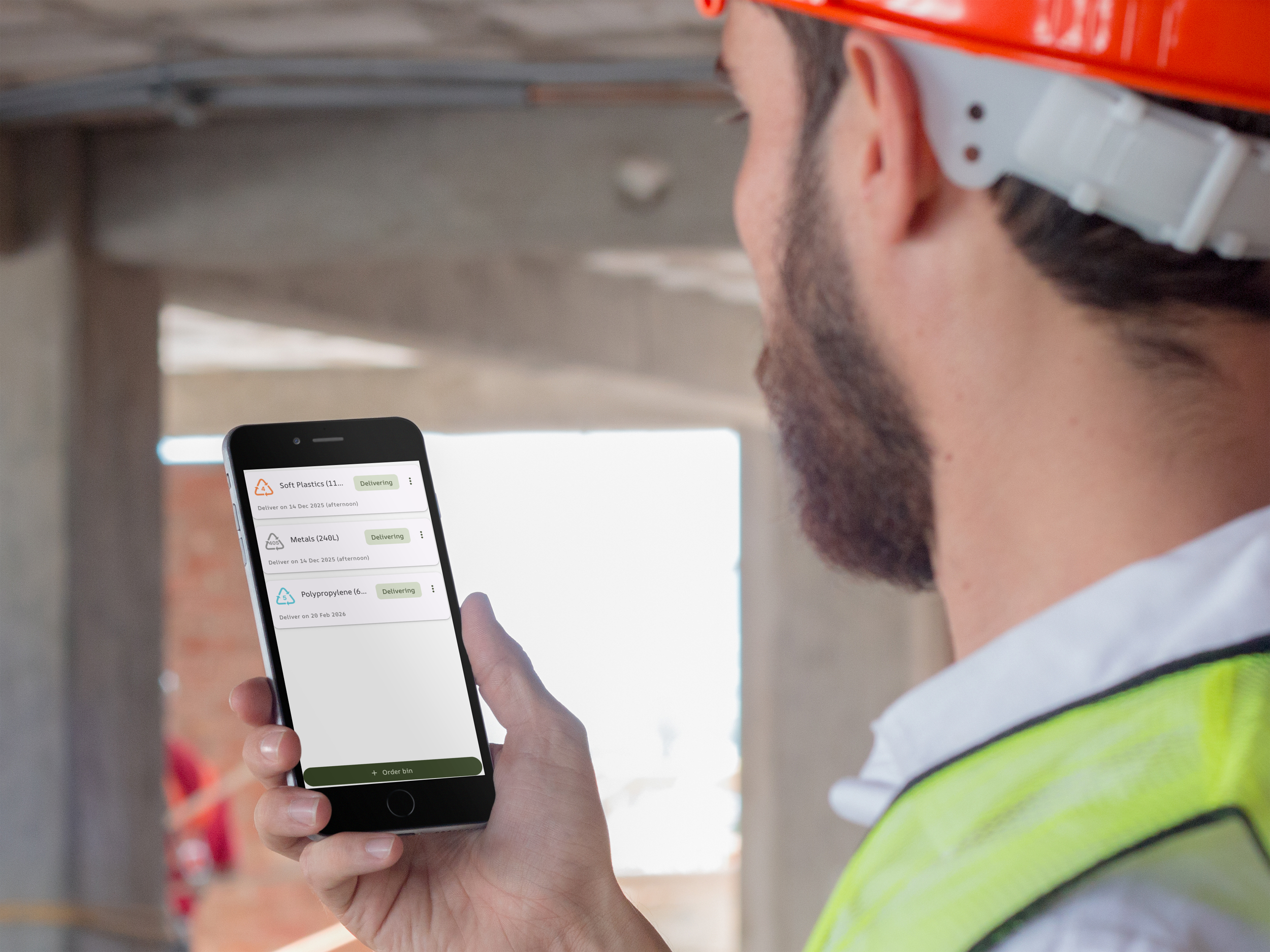 Image of man on construction site ordering a bin using a mobile app