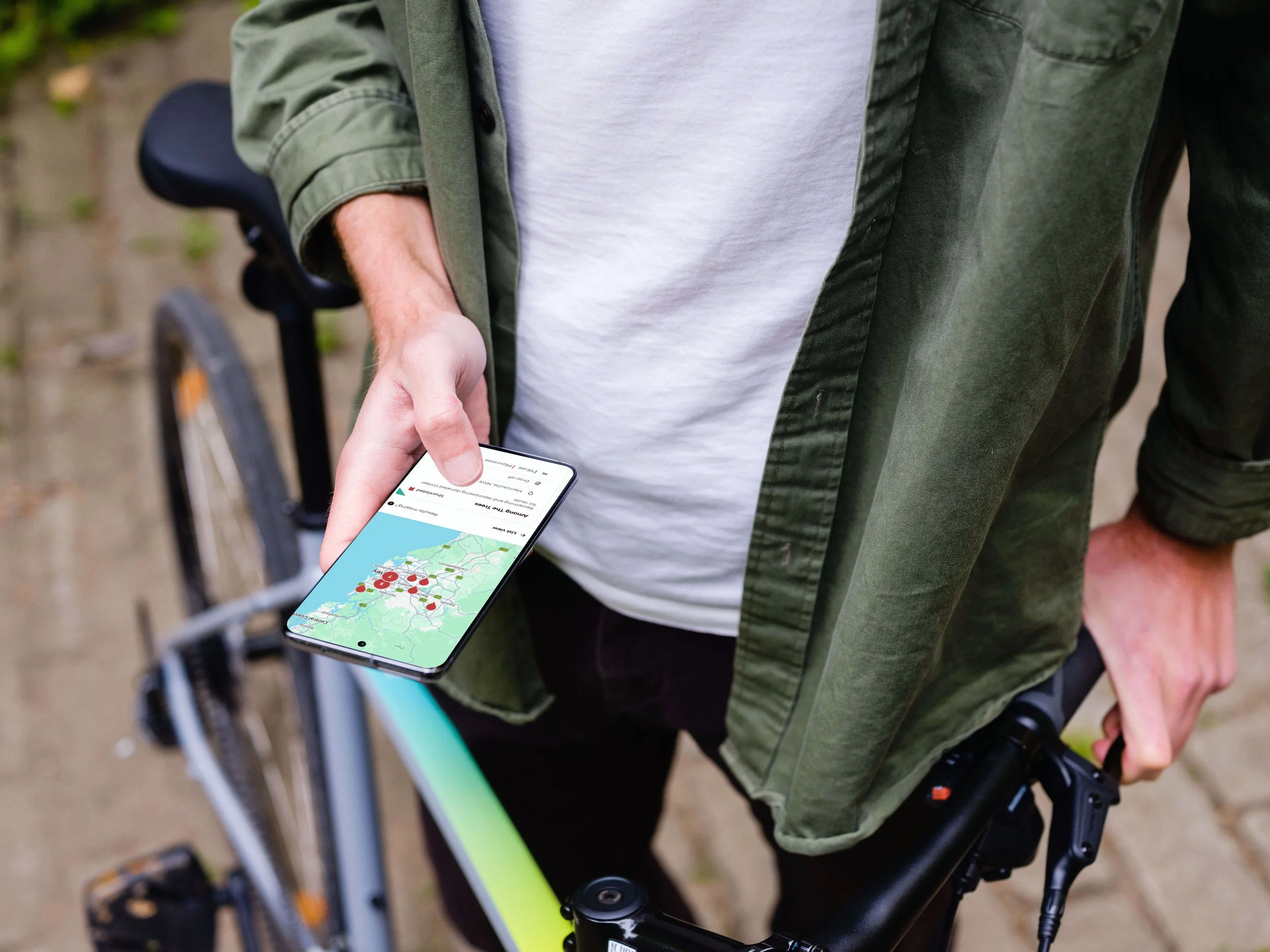 Man holding a bike and a mobile phone with screenshot of Recheck search
