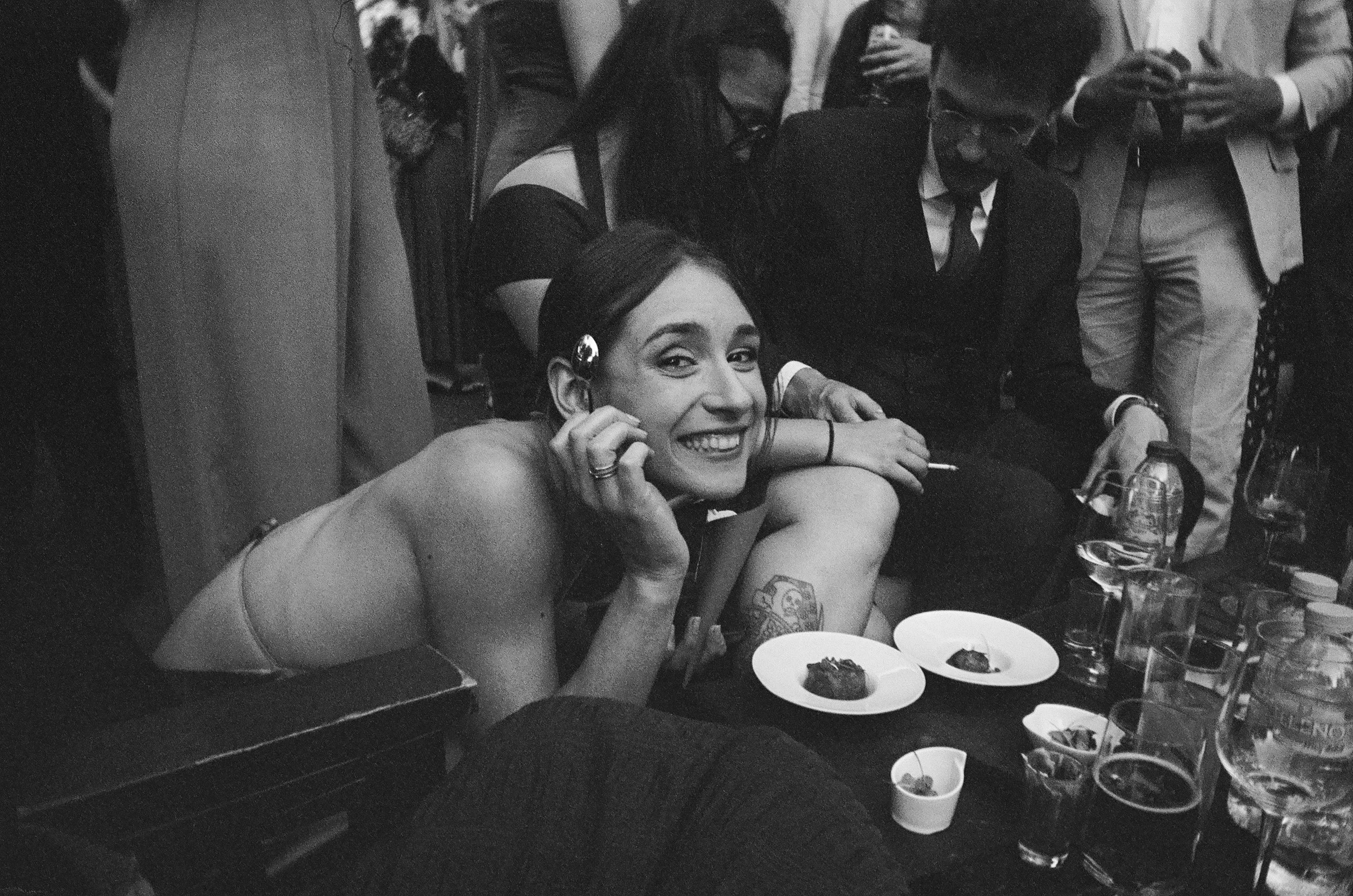 Wedding guest poses for photo during cocktail hour of summer wedding Madrid, Spain. Photographed on film.