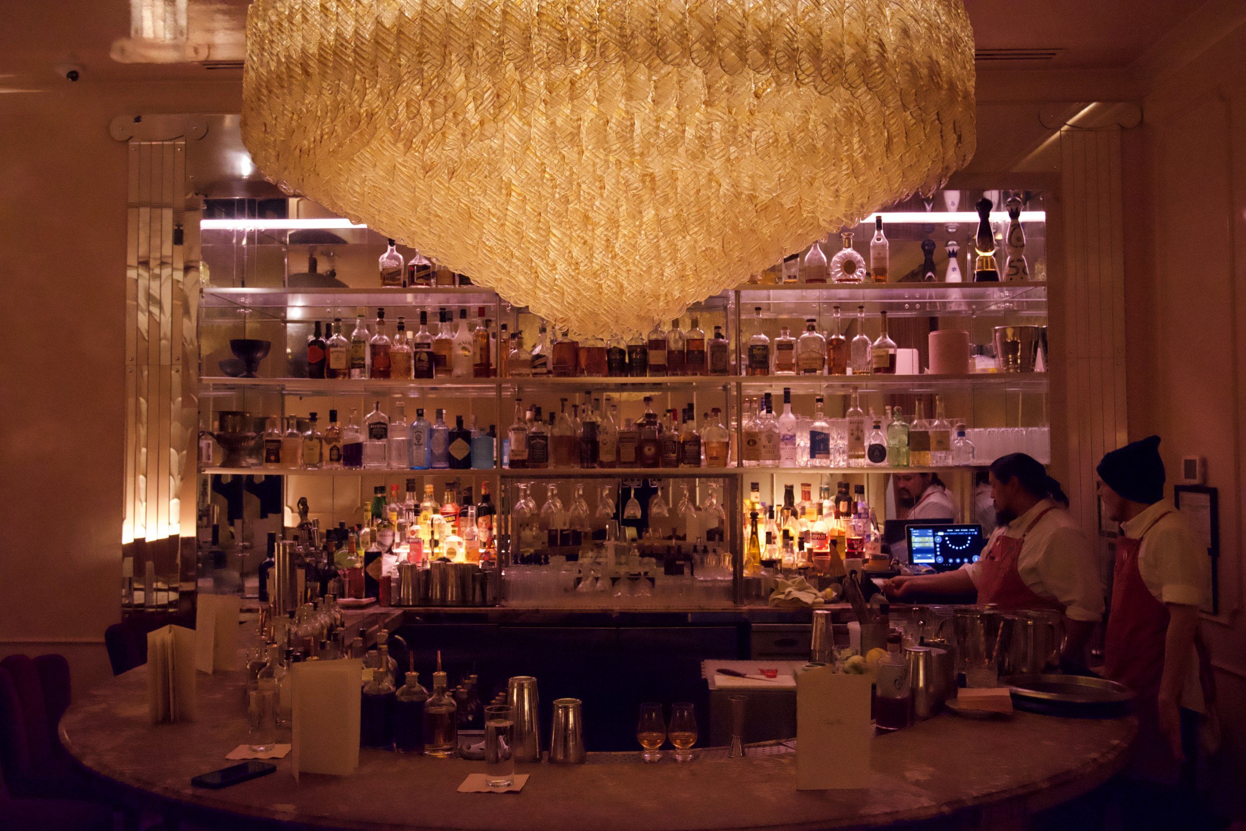 Luxury bar interior with chandelier and stocked shelves
