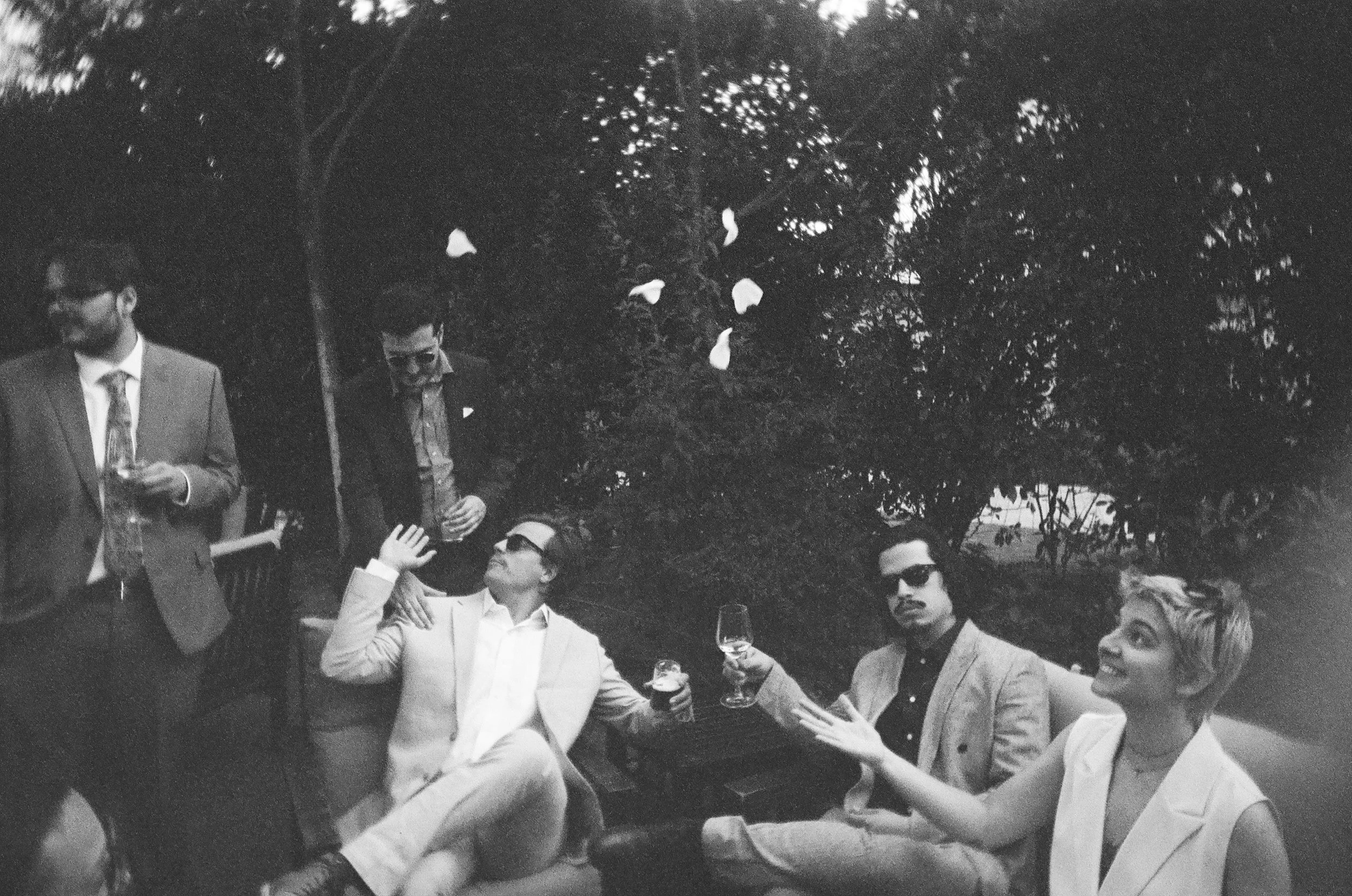Wedding guests hang out during cocktail hour of summer wedding in Madrid, Spain. Photographed on film.