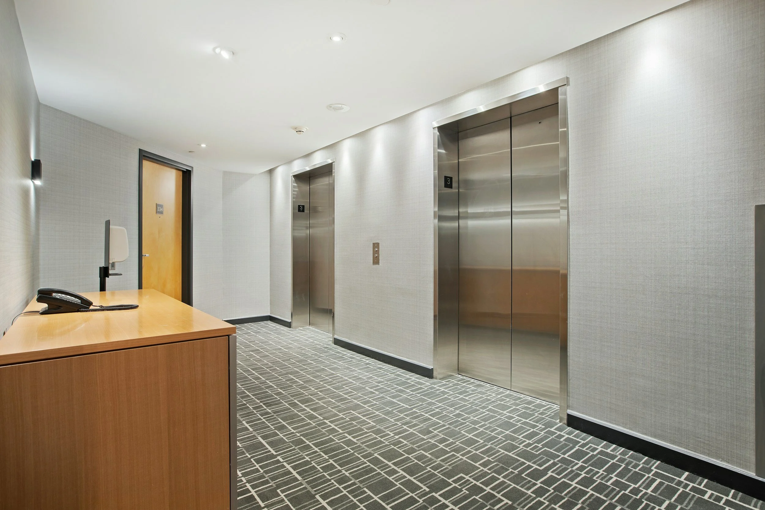 Waiting lobby with 2 closed elevators side-by-side