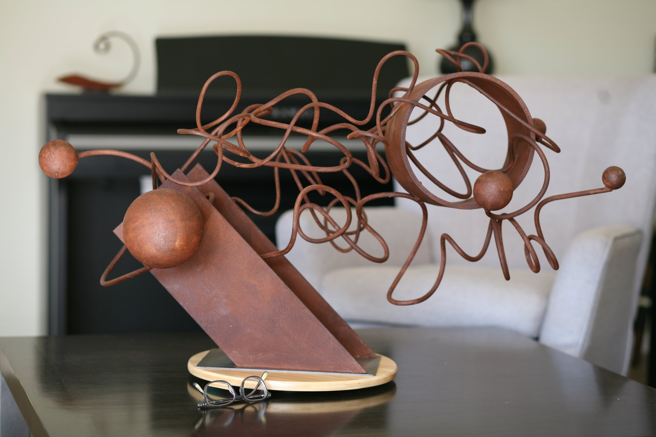 steel abstract sculpture with twisted rod, i beam, spheres, and cylinder