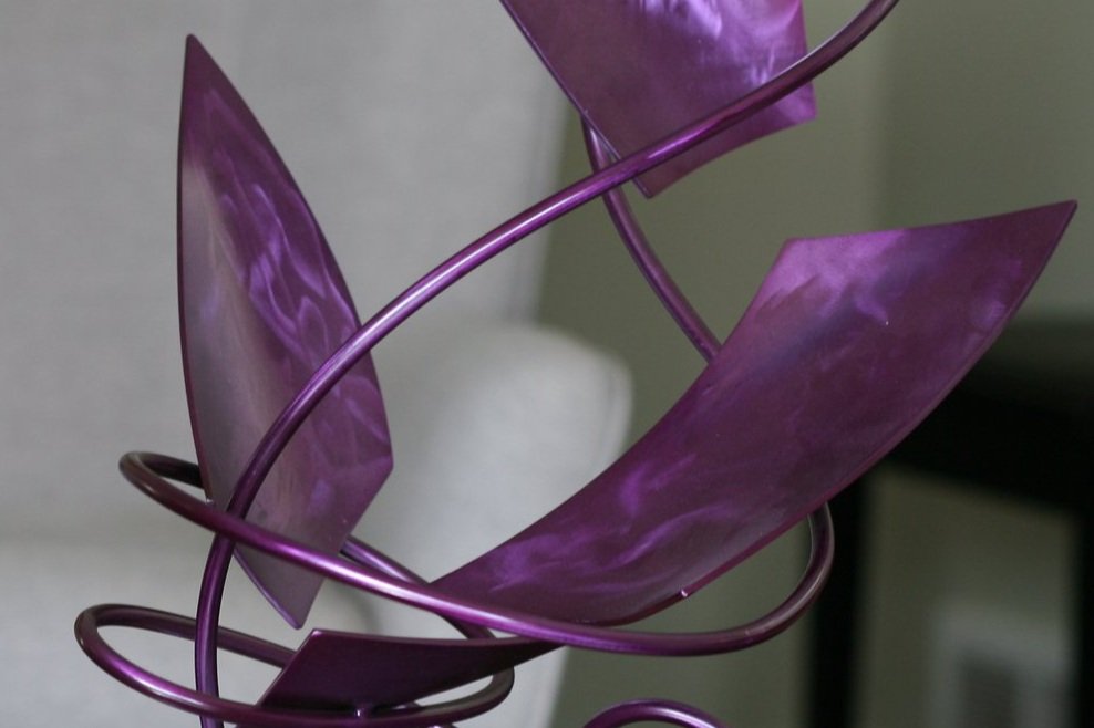 Detail of purple steel abstract sculpture with twisted rod, bent plates