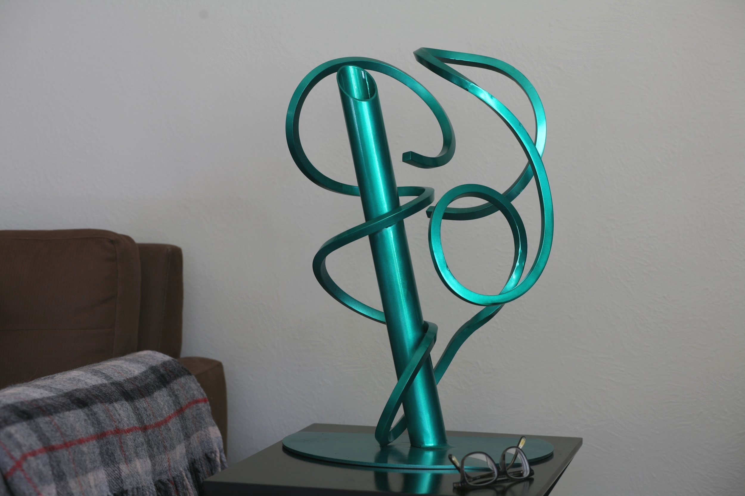 Twisted metal abstract sculpture with round tube, metallic green