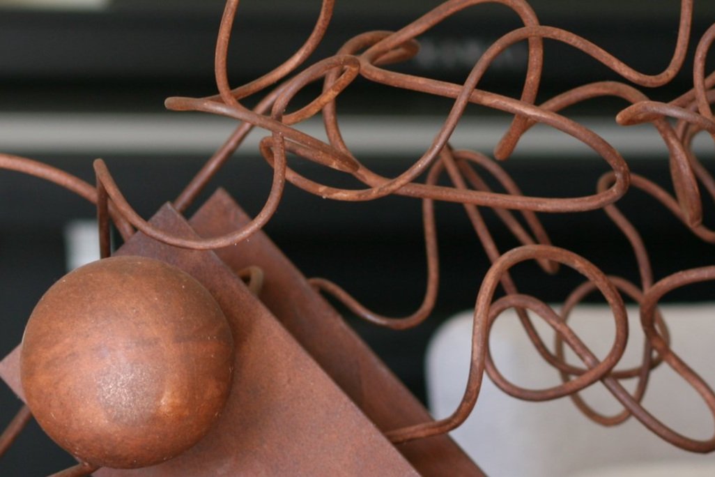 Detail of steel abstract sculpture with twisted rod, i beam, spheres, and cylinder