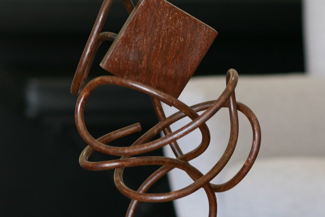 Detail of Rusted steel sculpture with twisted rod, base, and square