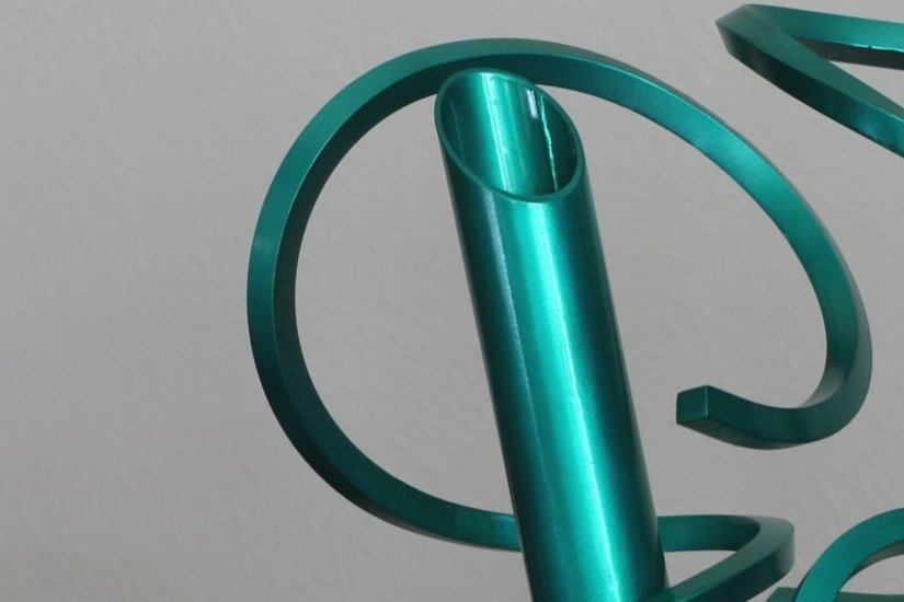 Twisted metal abstract sculpture with round tube, metallic green, detail