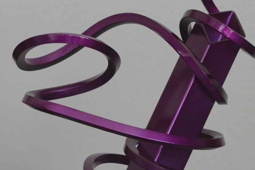 Twisted steel abstract sculpture with square tube, purple metallic, close up
