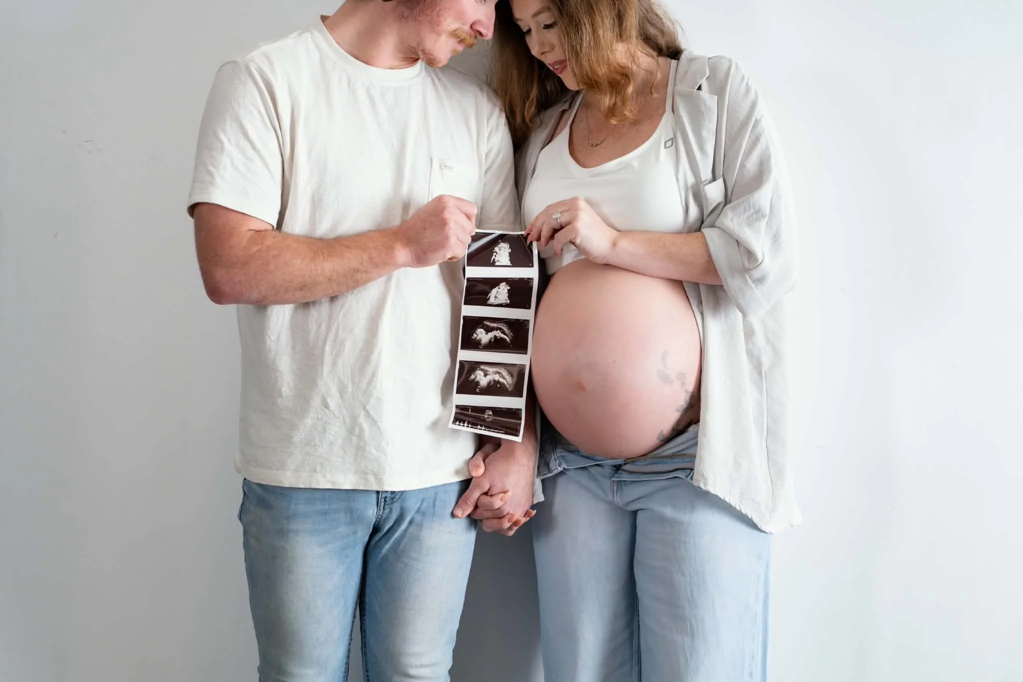 Couple holding ultersound picture for pregnancy announcement