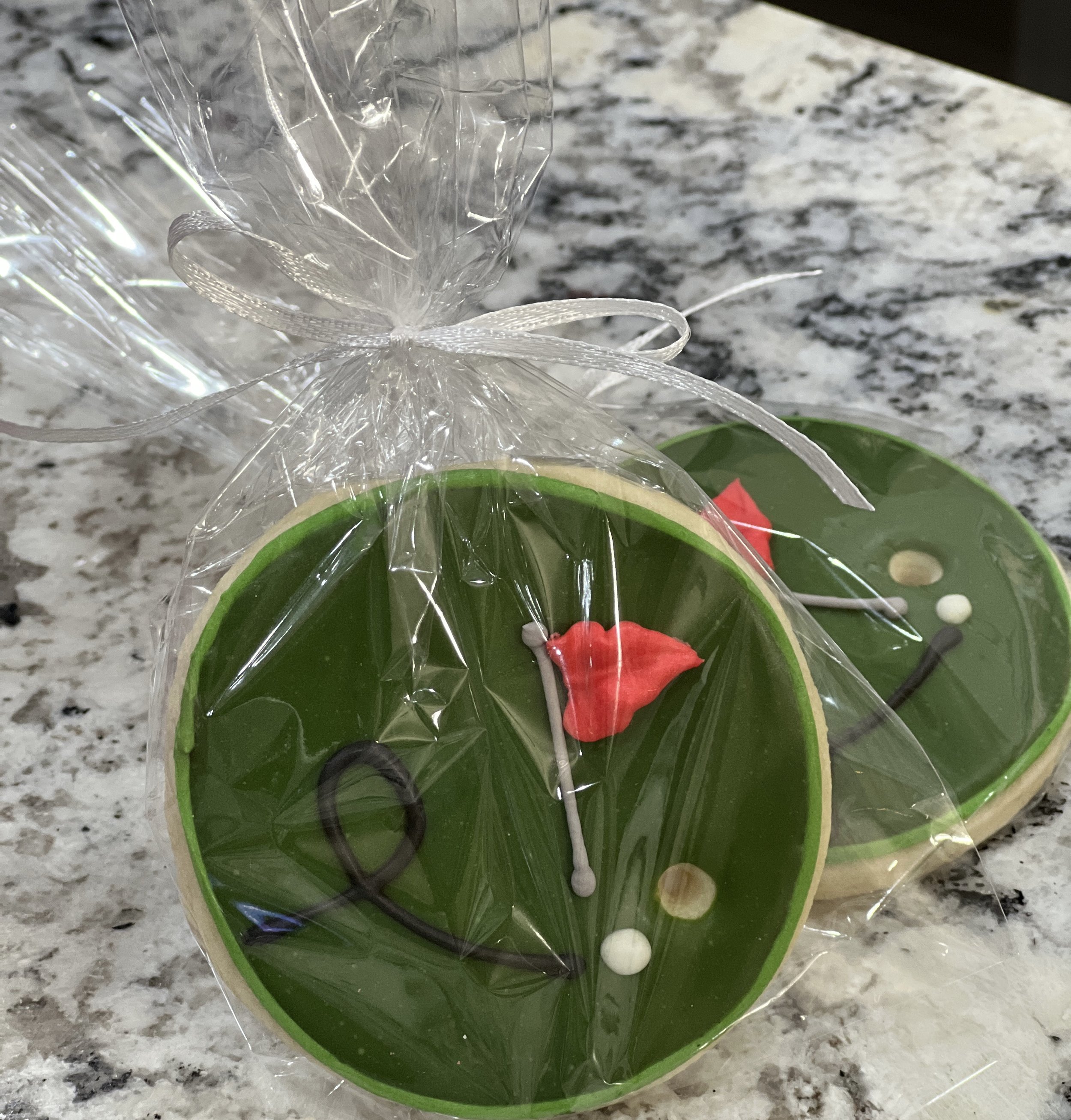 Golf-themed sugar cookies featuring designs like golf balls, tees, and putting greens