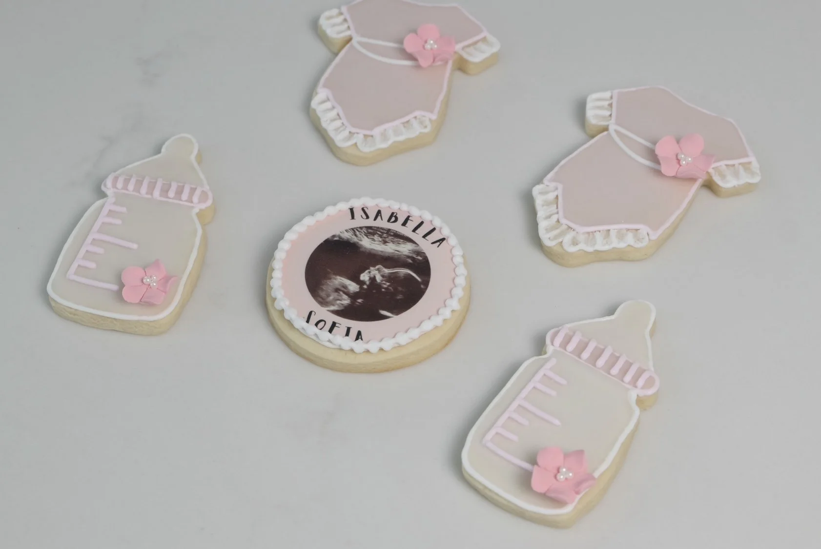 Custom onesie-shaped cookies, perfect for a baby shower or newborn celebration