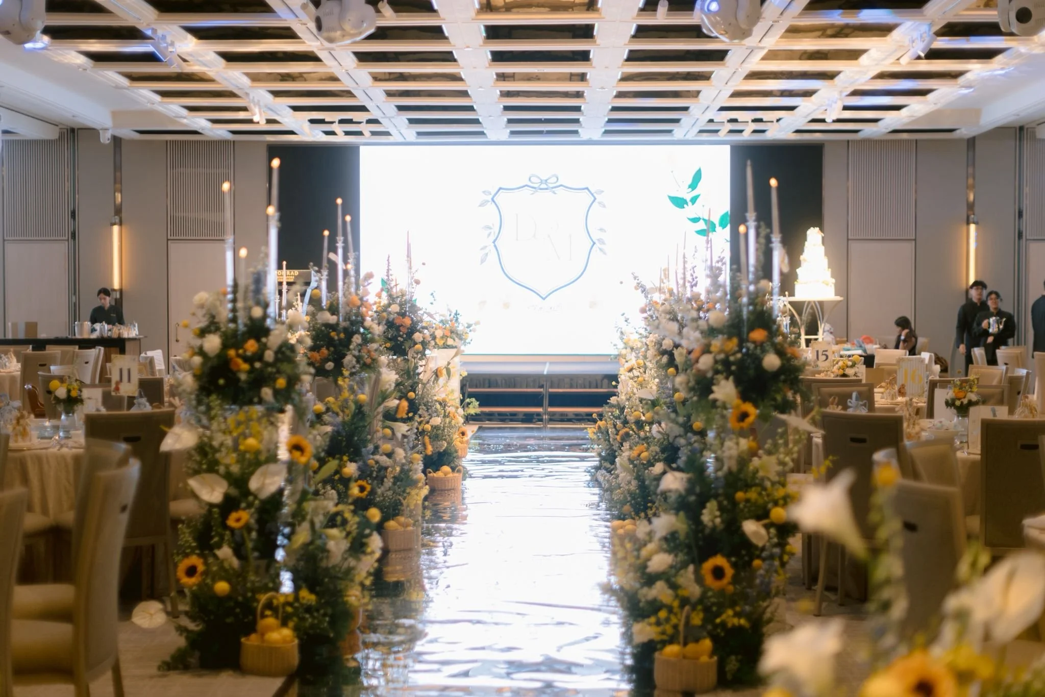 Polished mirror aisle lined with yellow florals and candles during Merilynn and Daryl’s wedding ceremony.