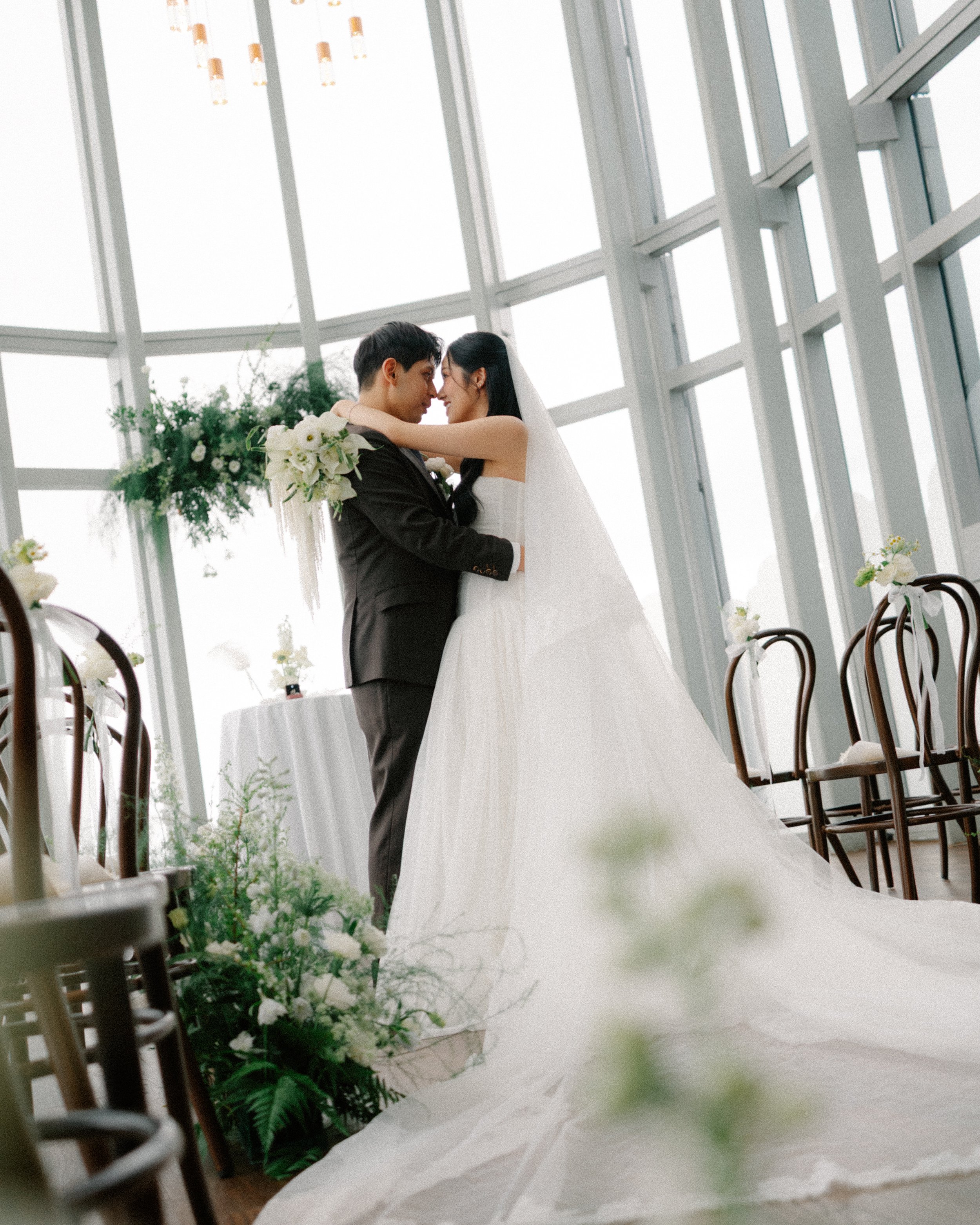 Bride and groom holding hands at reception table during emotional wedding moment at 1-Atico.