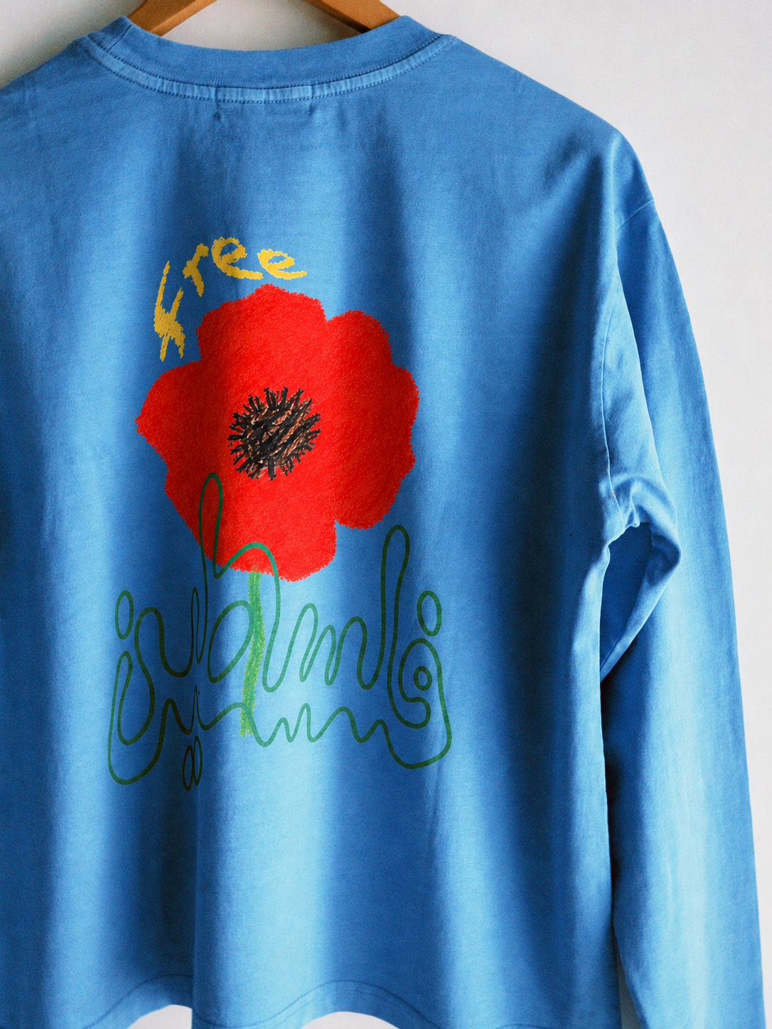 Blue shirt with vivid red flower print.png