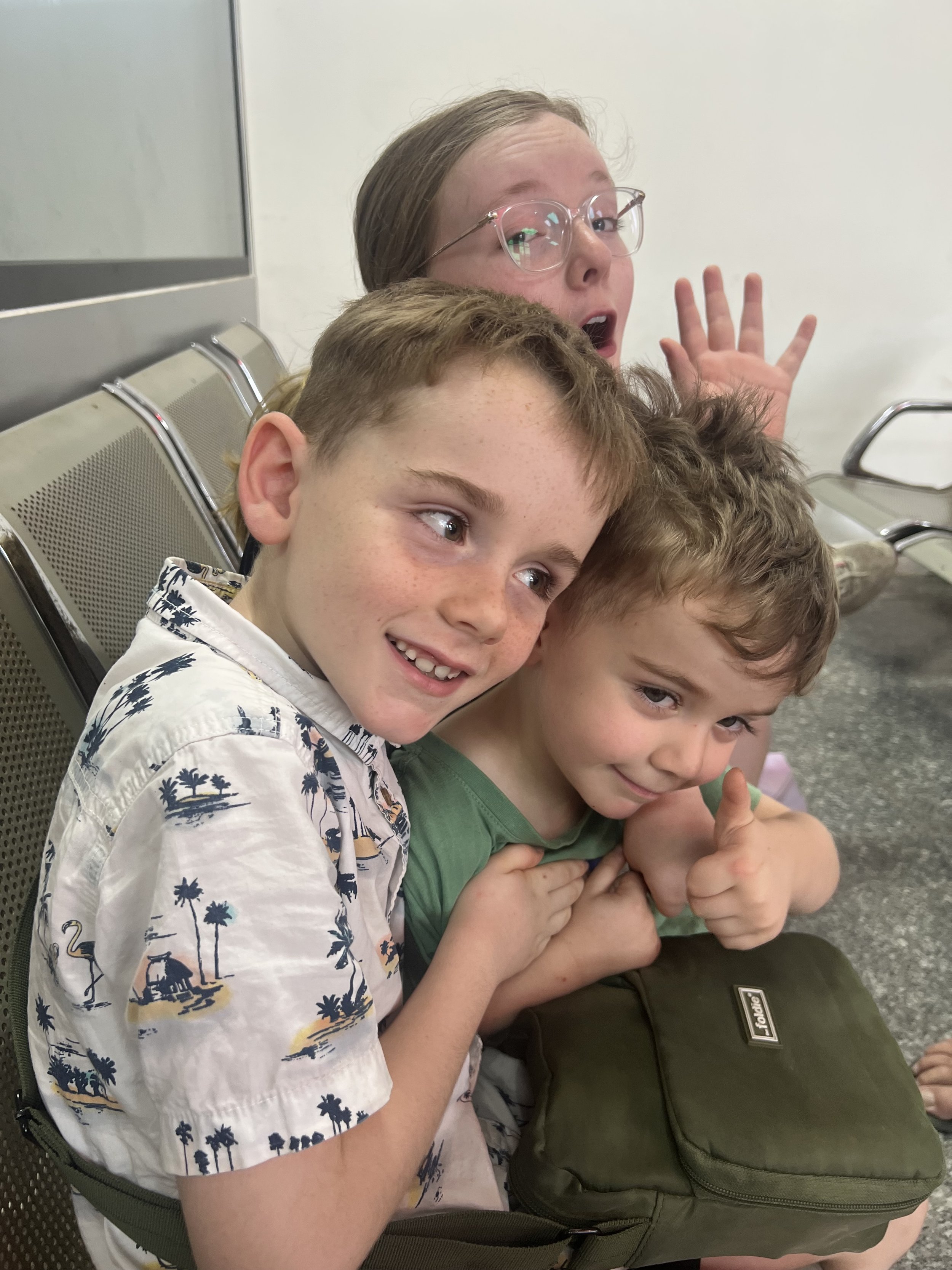 Kids waiting during the Vietnam to Laos visa run, prepared with snacks and their bags