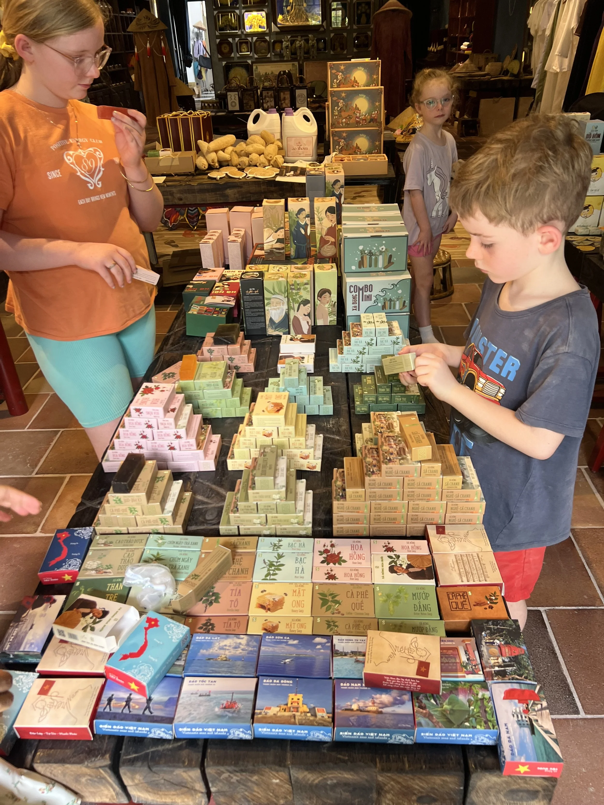 Kids exploring handmade herbal soaps and products at a local workshop in Ninh Binh