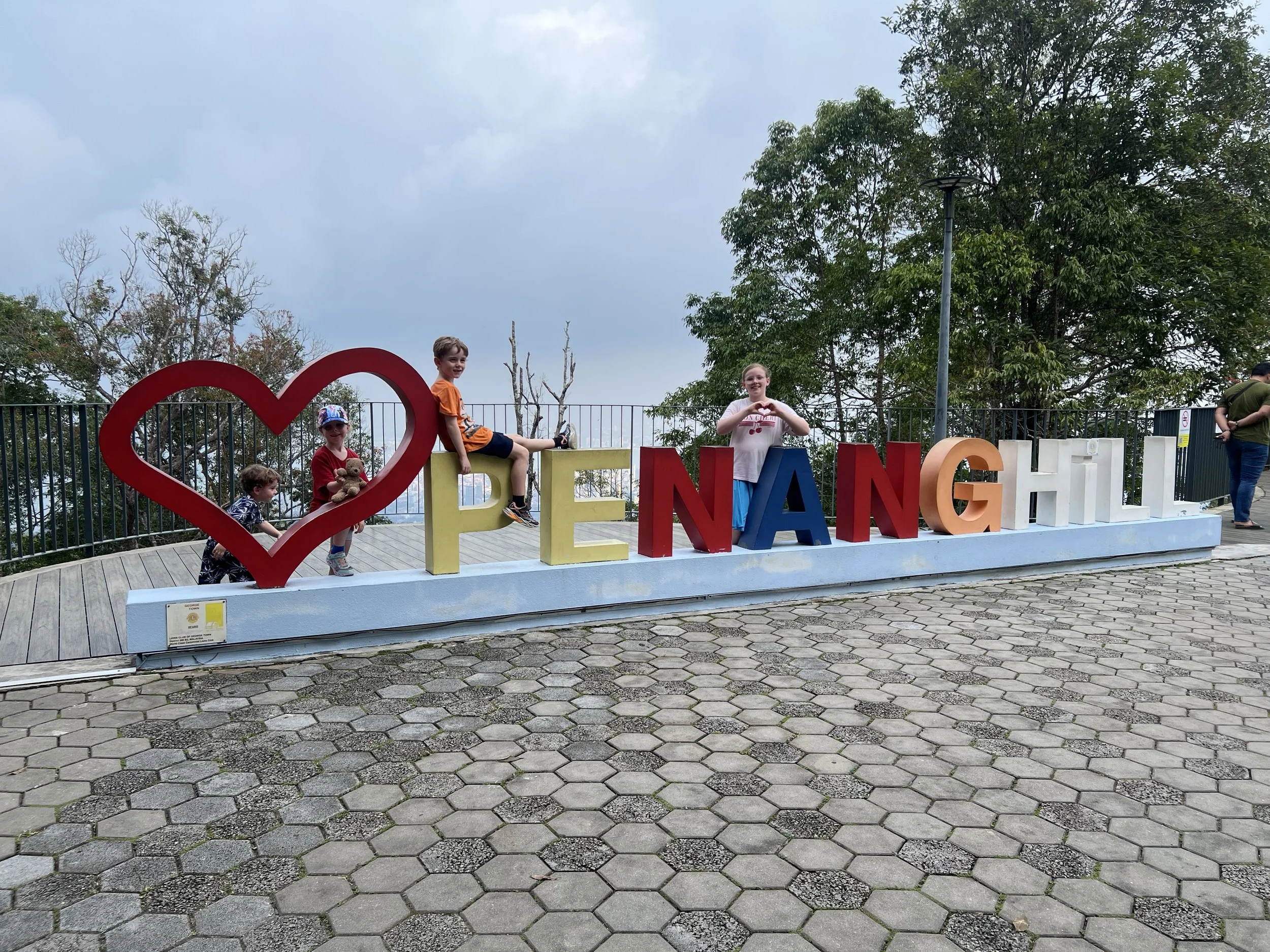 Kids climbing on the giant Penang Hill letters sign in Penang, Malaysia