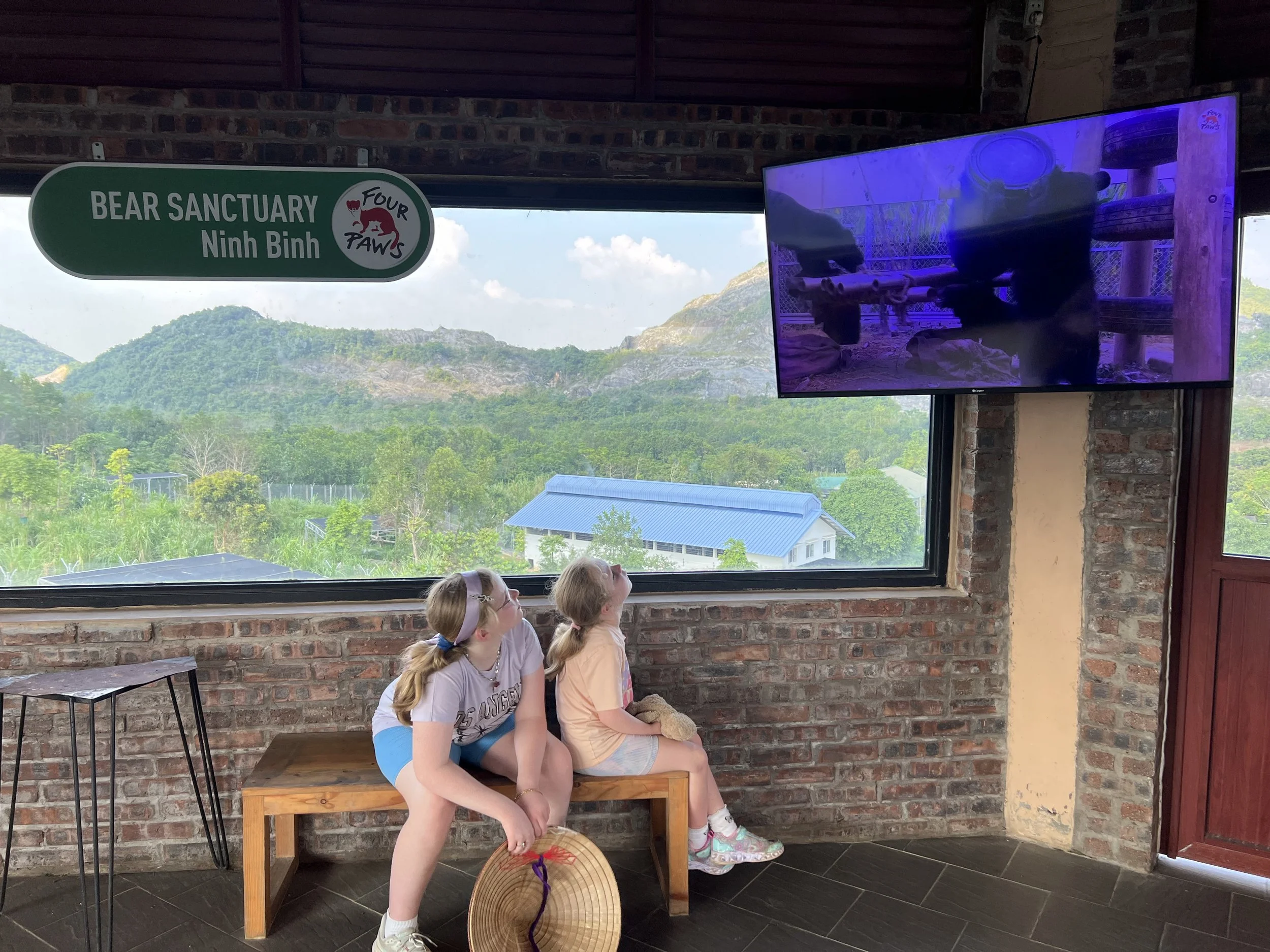Two girls watching a bear rescue video at the Bear Sanctuary Ninh Binh visitor centre