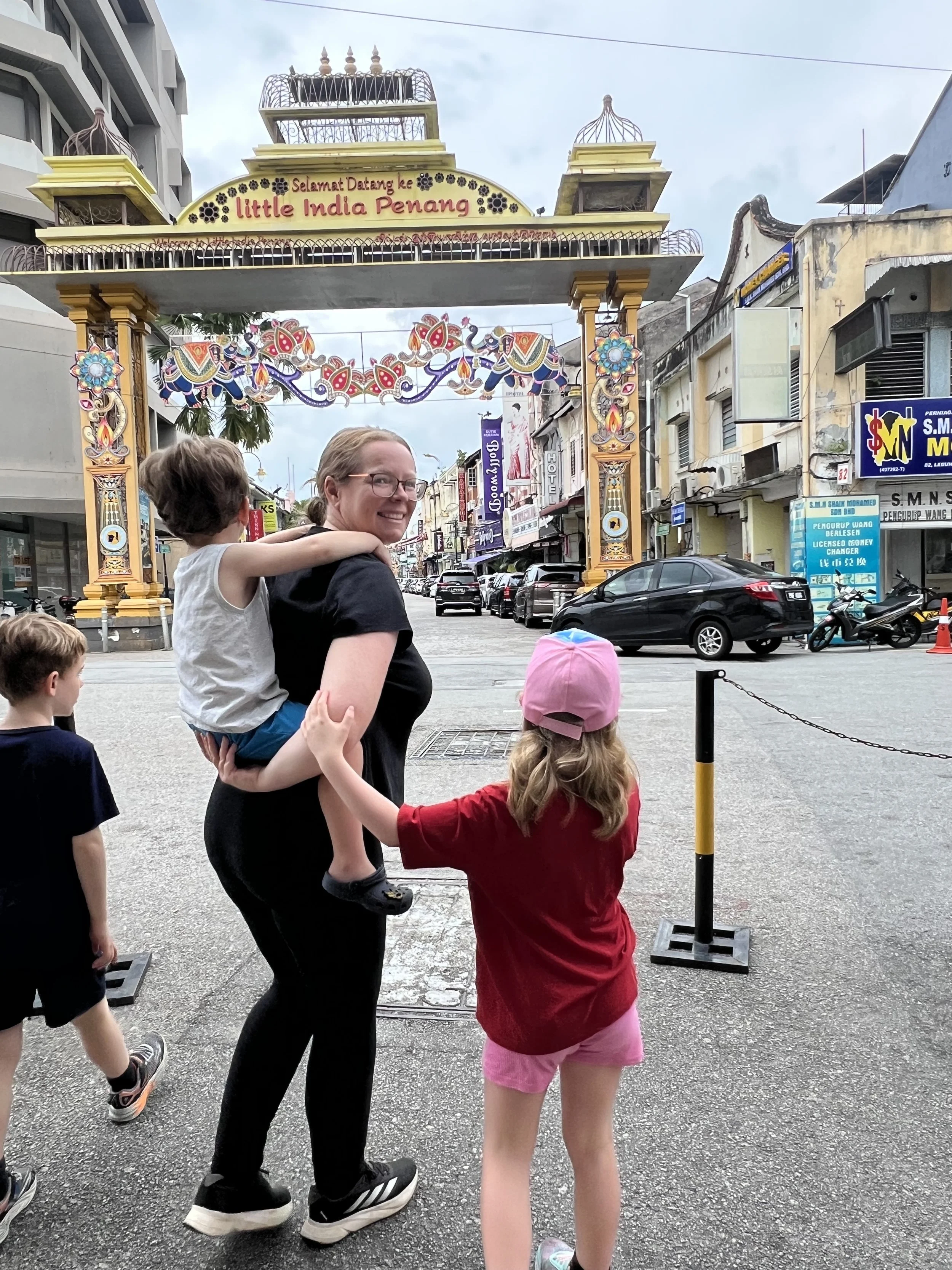 Mum and kids under the Little India Penang archway in George Town, Malaysia