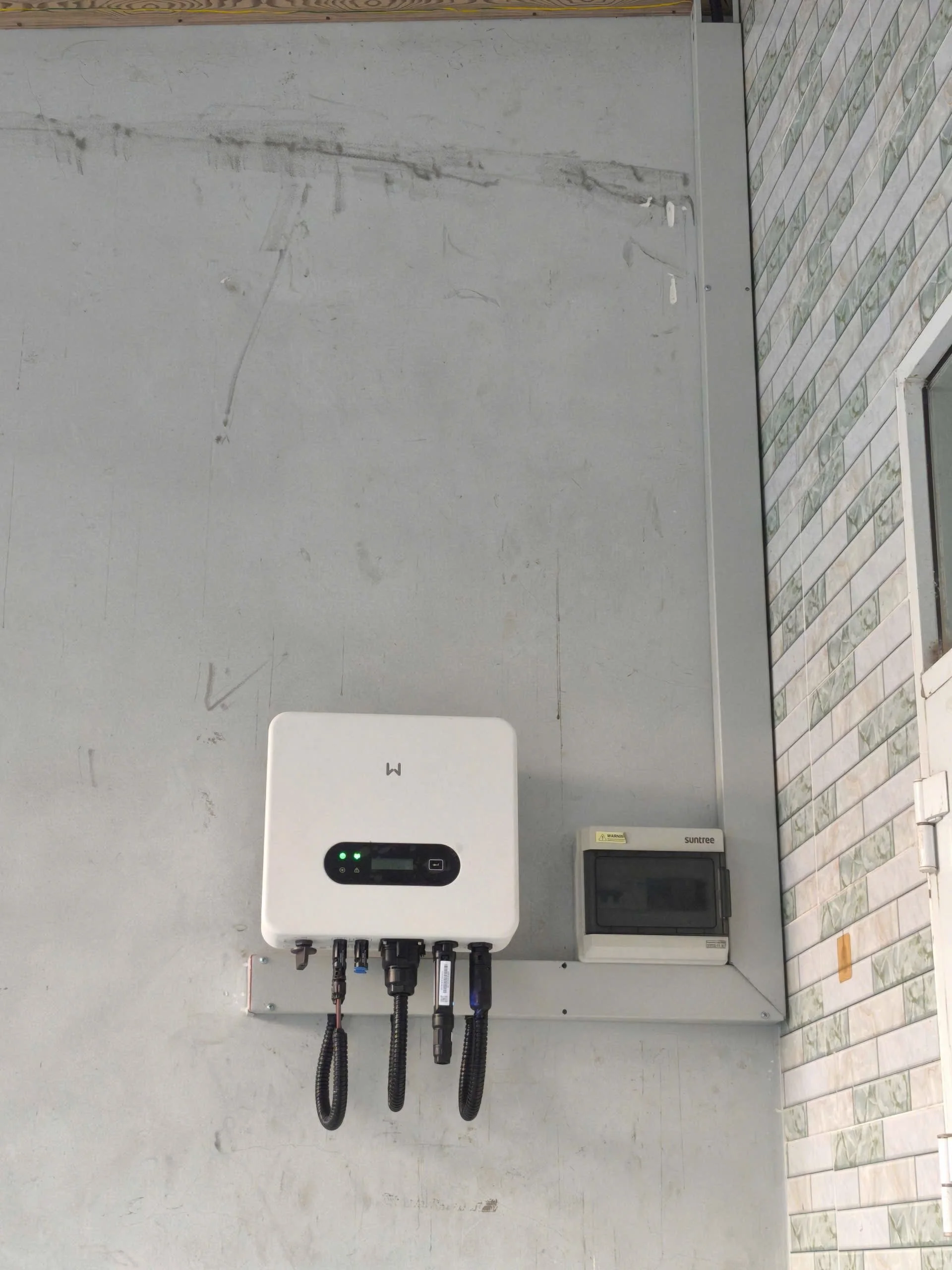 GoodWe solar inverter is on the wall, connected and working with 2 green lights being visible