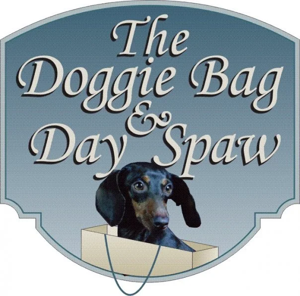 Logo for The Doggie Bag & Day Spaw featuring a dachshund in a bag.