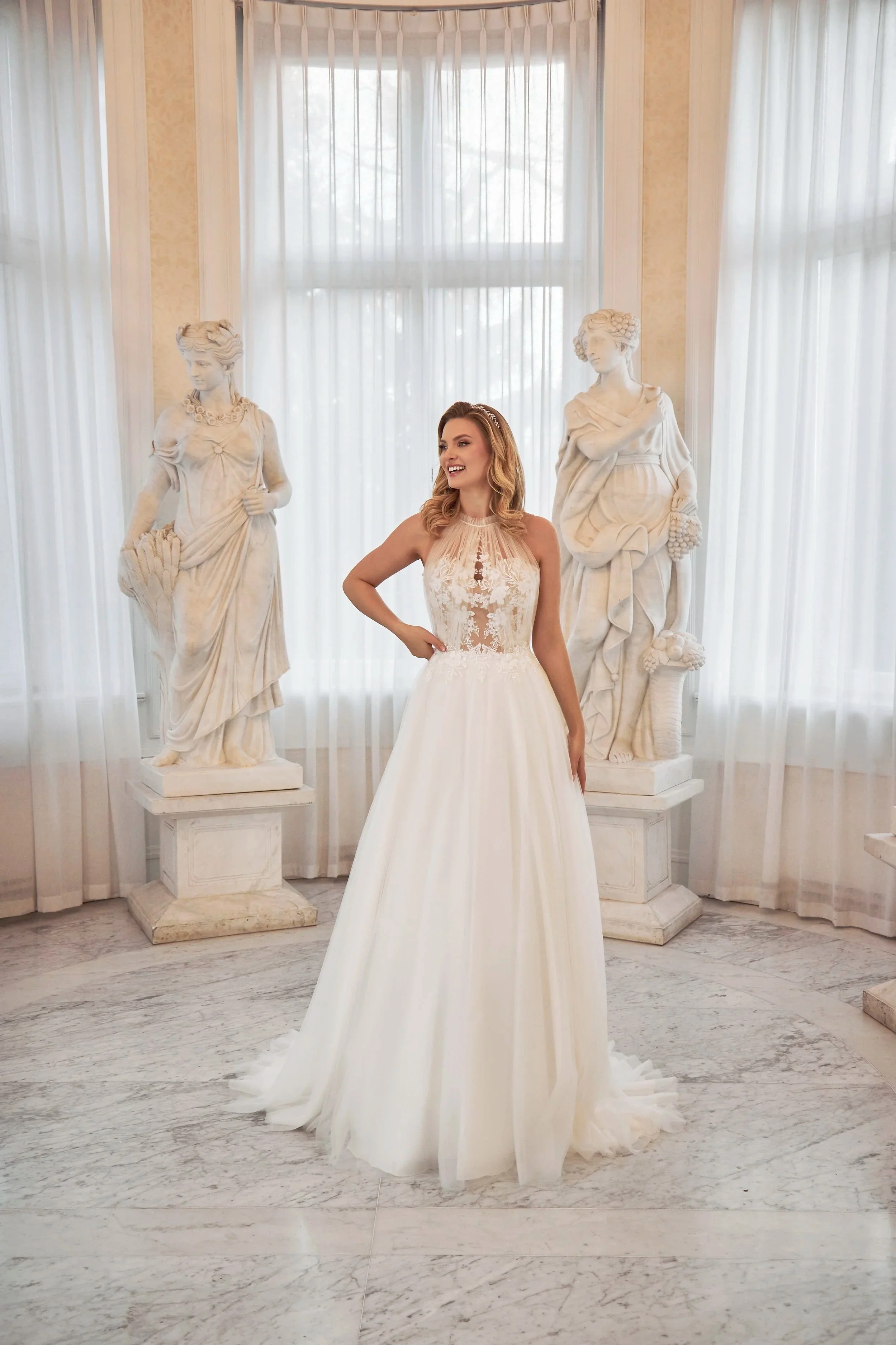 Full front view of Lia Bella Model Toutou, a flowing tulle A-line wedding dress with a high illusion neckline and floral lace bodice.