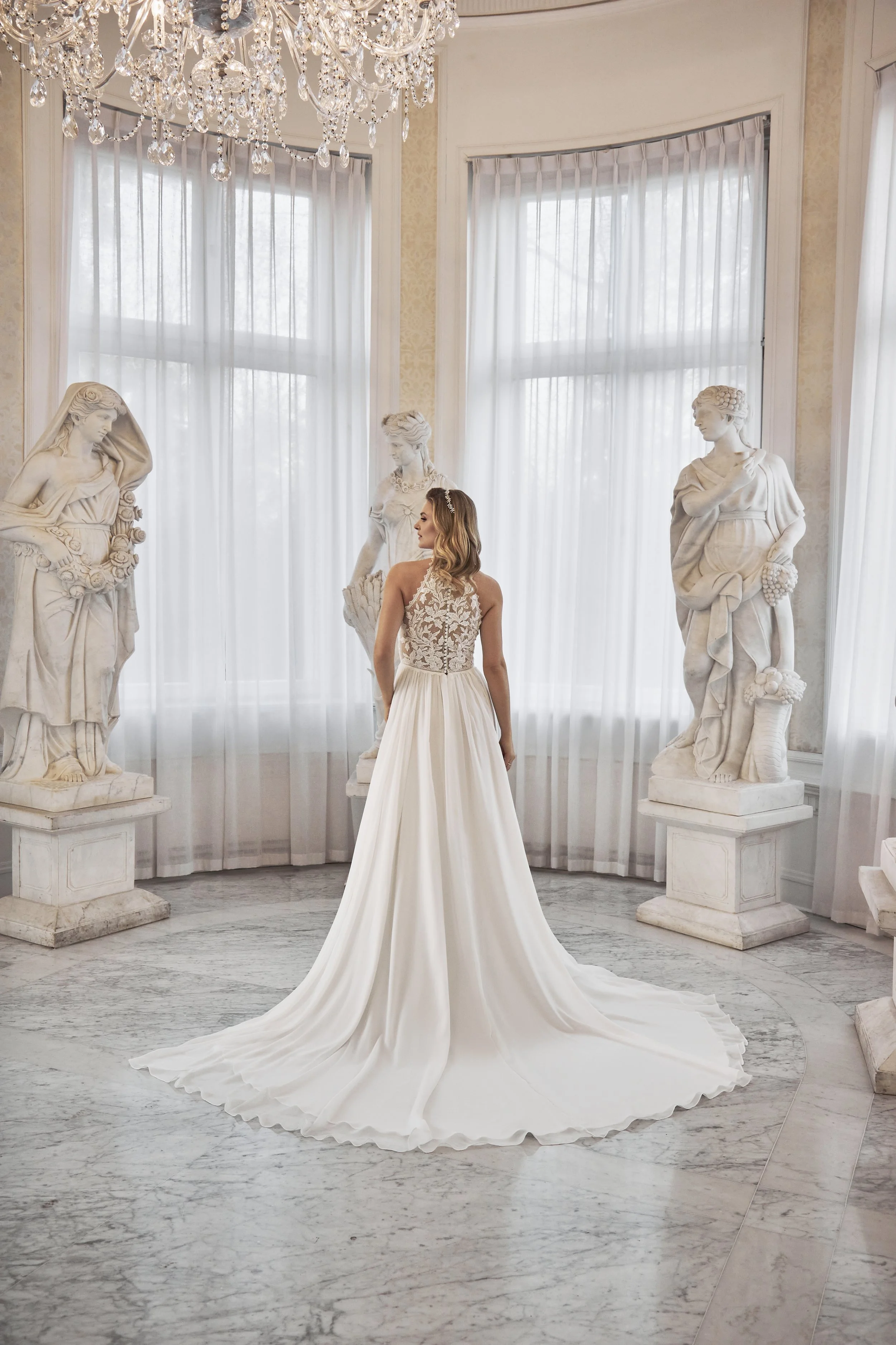 Full back view of Lia Bella Model Tokio showing the sheer lace back, covered buttons and softly flowing chapel train.