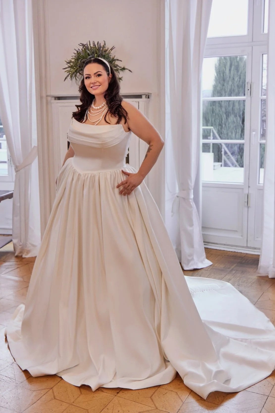 Wide front view of Lia Bella Model Tila displaying the softly gathered satin skirt and elegant ball-gown silhouette.