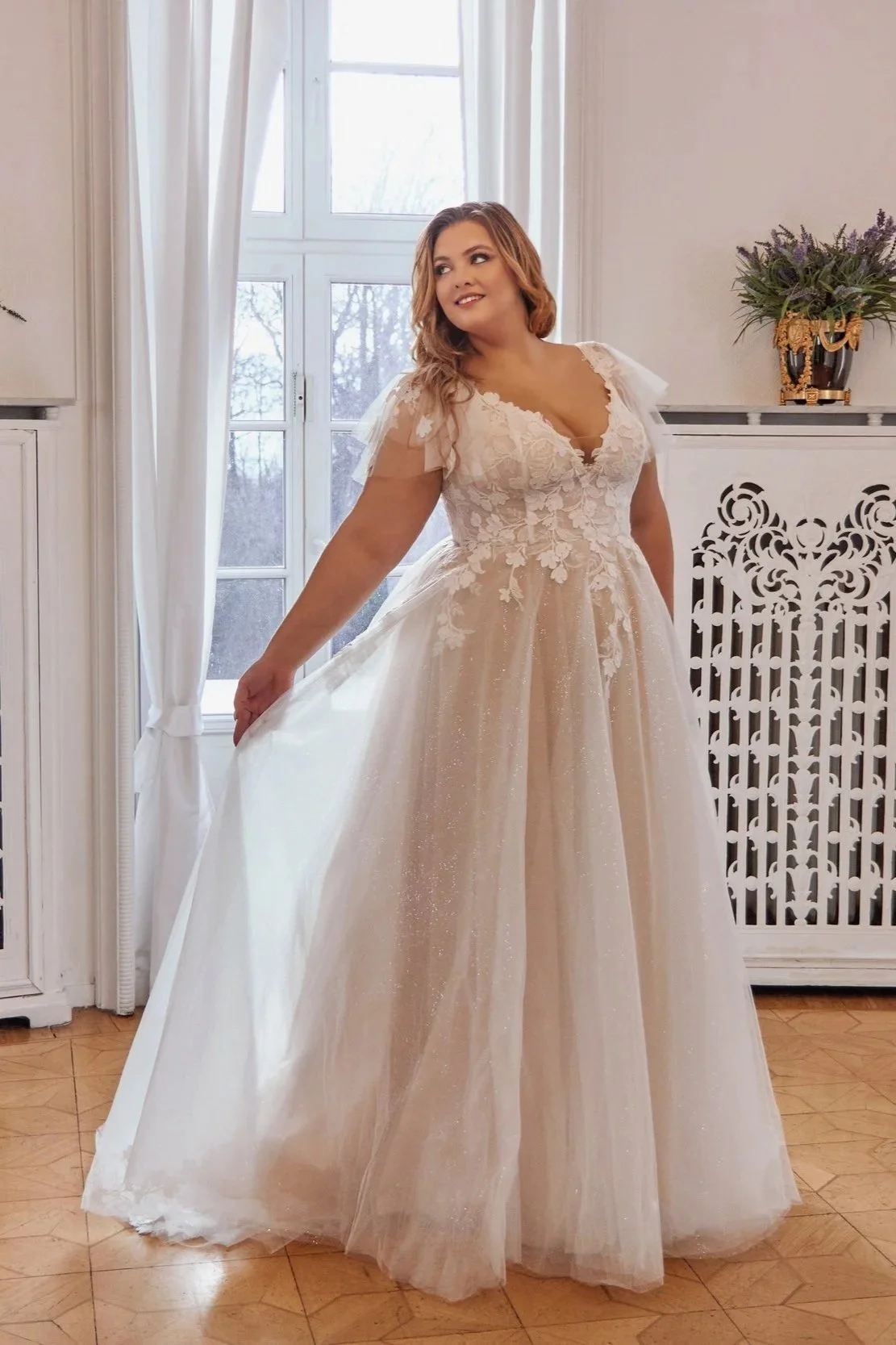 Wide full-length view of Lia Bella Tsuna showing its softly voluminous A-line silhouette and shimmering tulle skirt.